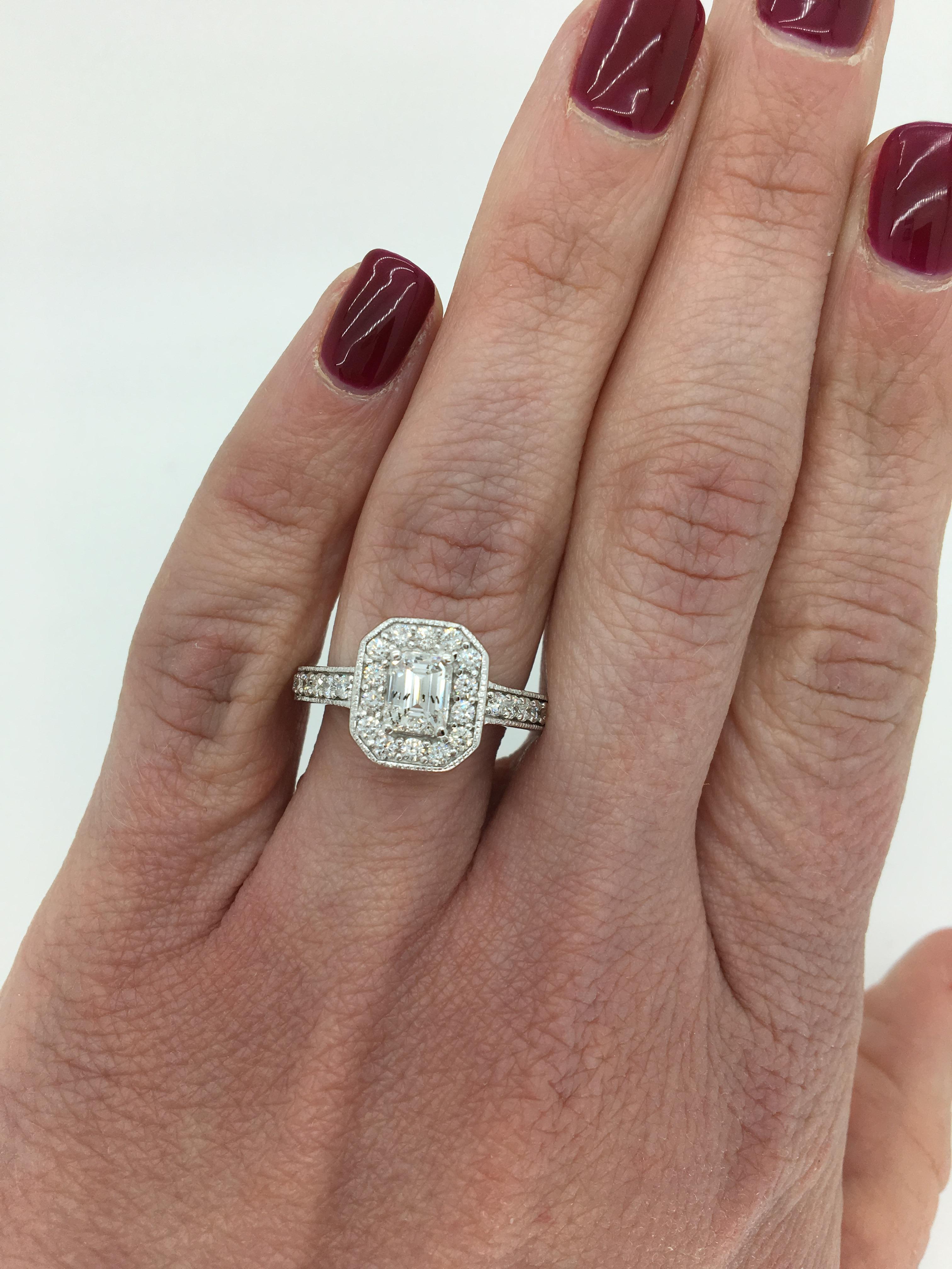Emerald cut halo style diamond ring with filigree detail crafted in 14K white gold with yellow gold accents.

Center Diamond Carat Weight: Approximately .59CT
Center Diamond Cut: Emerald
Center Diamond Color:  F-G
Center Diamond Clarity: I1
Total