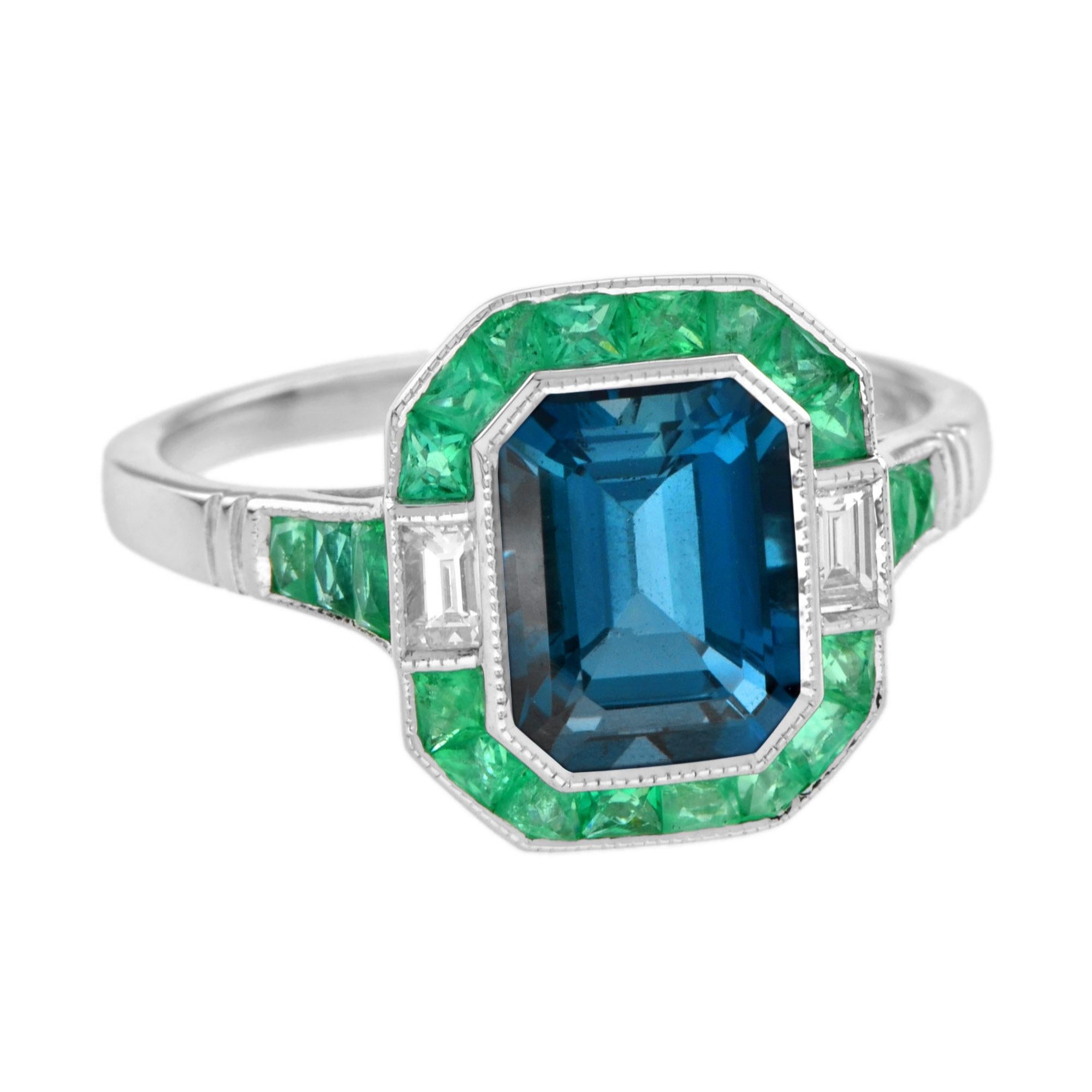 Centering an emerald cut London blue topaz, accented by French cut Emeralds, enhanced by baguette cut diamonds. This Art Deco inspired ring is a perfect piece for an engagement ring, or to commemorate an anniversary.

Ring Information
Style: