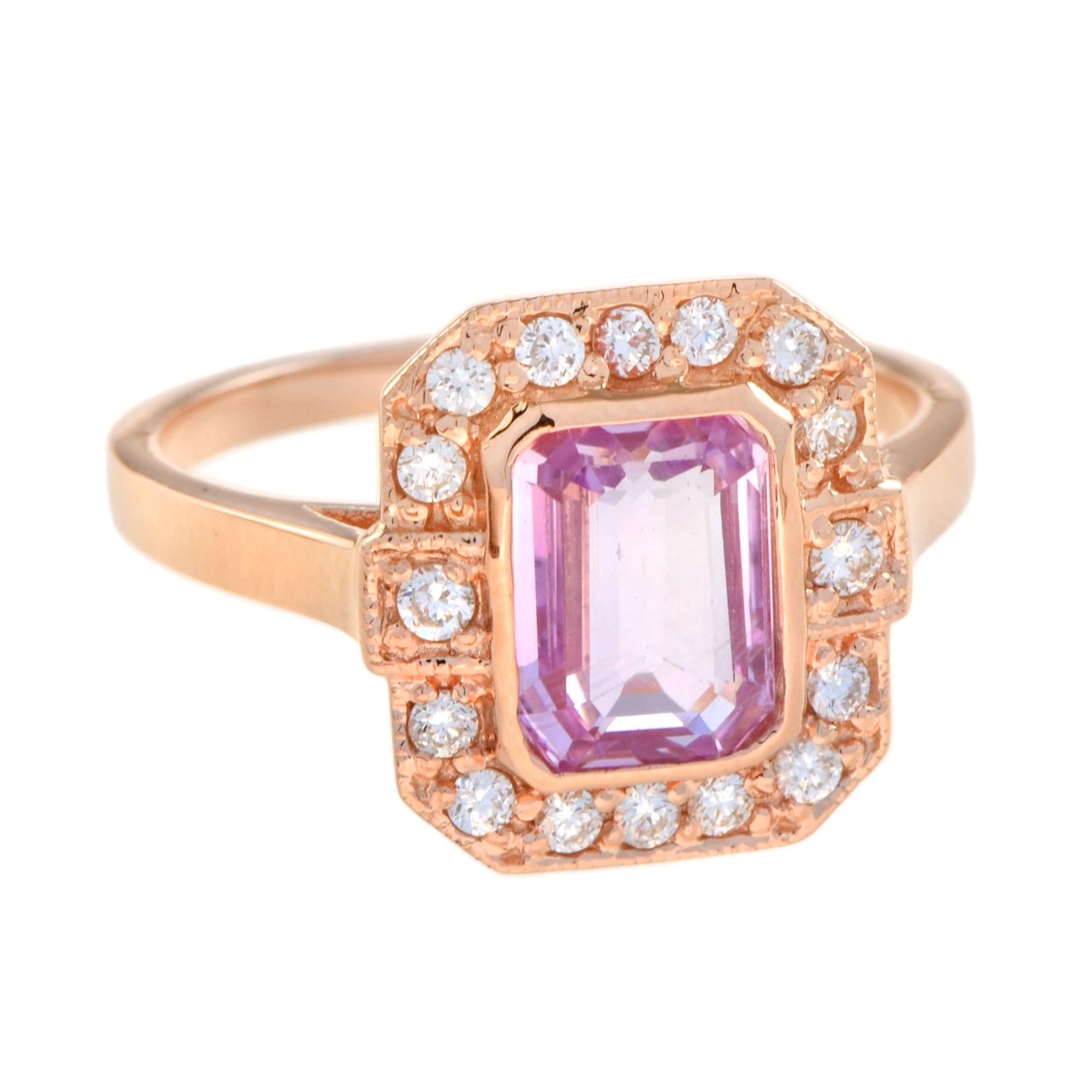 A gorgeous Art Deco inspired emerald cut pink sapphire is presented in classic Art Deco style. The glorious gemstone radiates from within a sparkling halo of bright round brilliant cut diamonds. 14K Rose Gold. 
Ring Information
Style: Art