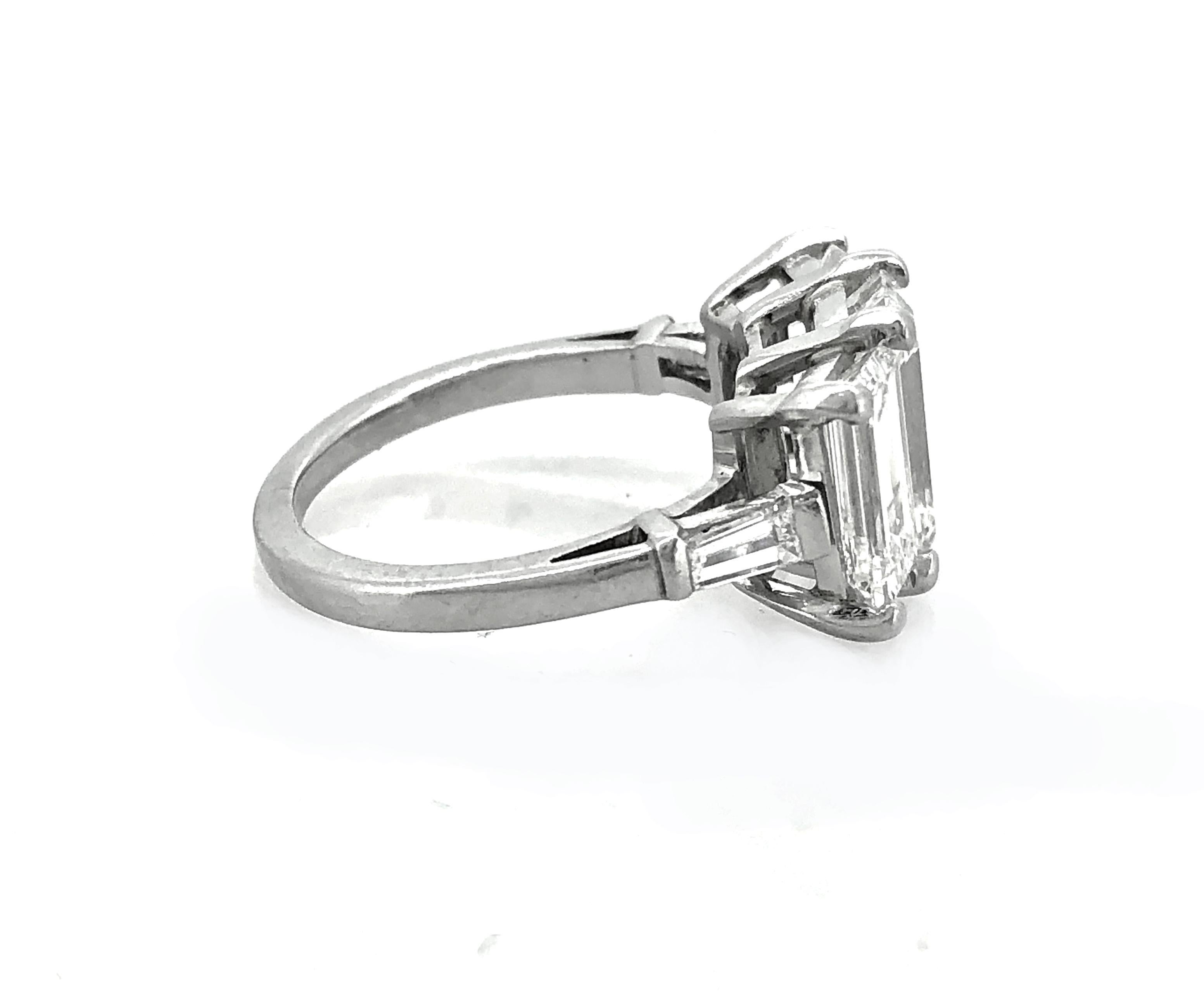 An exquisite 3-stone emerald cut diamond Estate engagement or fashion ring featuring a center emerald cut diamond weighing approximately 2.65ct. with VVS2 clarity and I color. There are two emerald cut diamonds weighing approximately 1.25ct. apx.