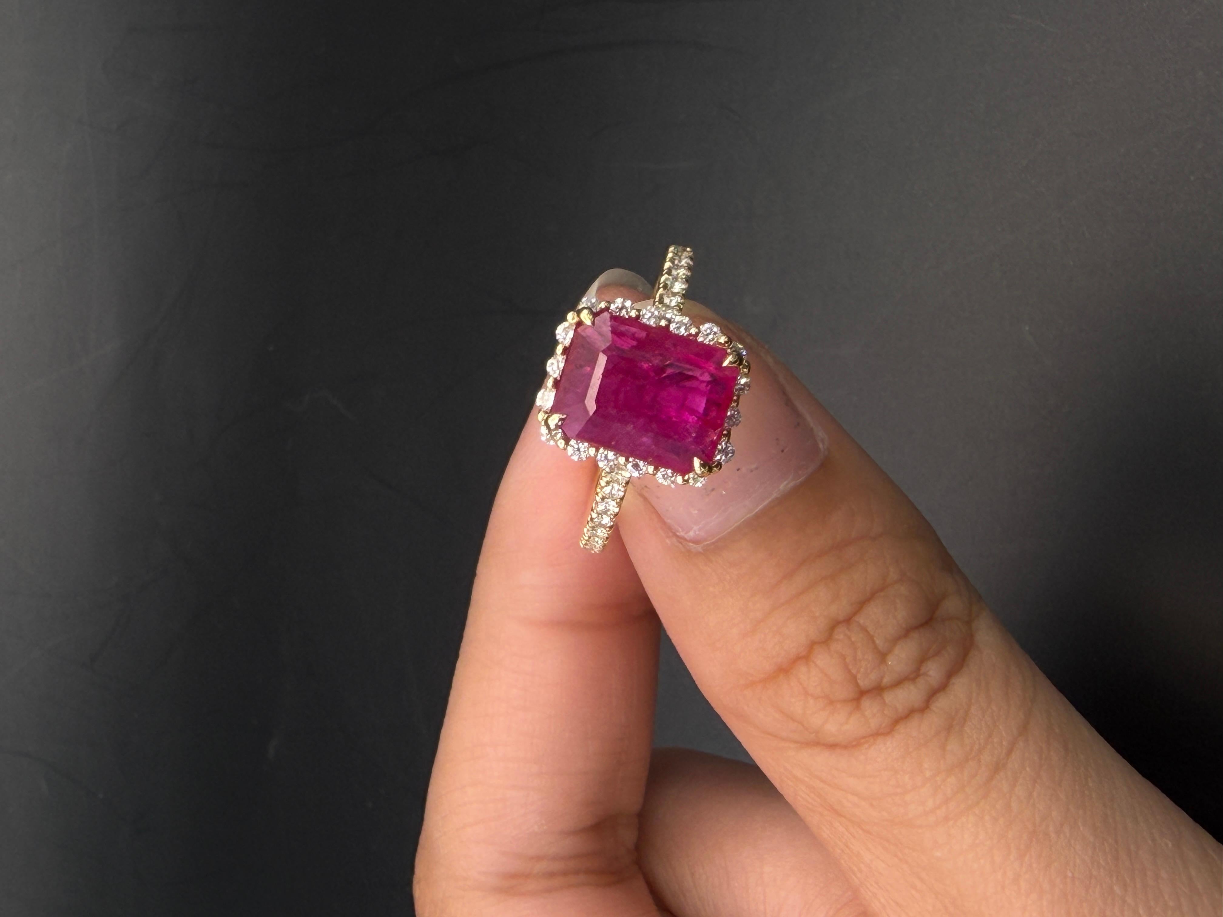 Questo raffinato anello presenta un rubino naturale da 2,39 carati con taglio a smeraldo, ammirato per il suo ricco colore rosso e il suo taglio a smeraldo equilibrato. Il rubino è incorniciato da un'aureola di diamanti tondi e brillanti che