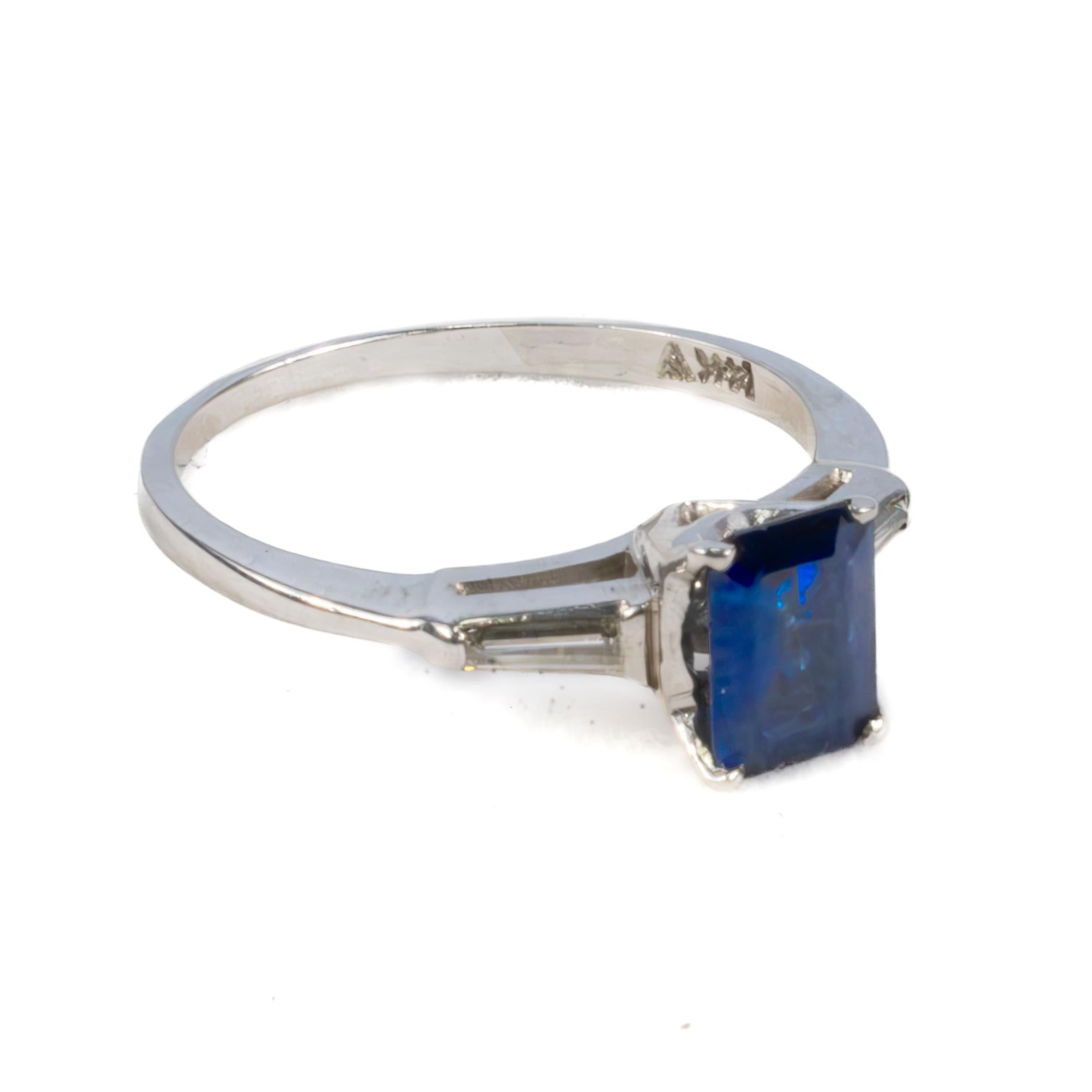 Sapphire and Diamond Engagement Ring

A timeless and sophisticated engagement ring, this white gold setting showcases a rich, deep blue emerald-cut sapphire at its center. The striking sapphire is complemented by two elegant tapered baguette