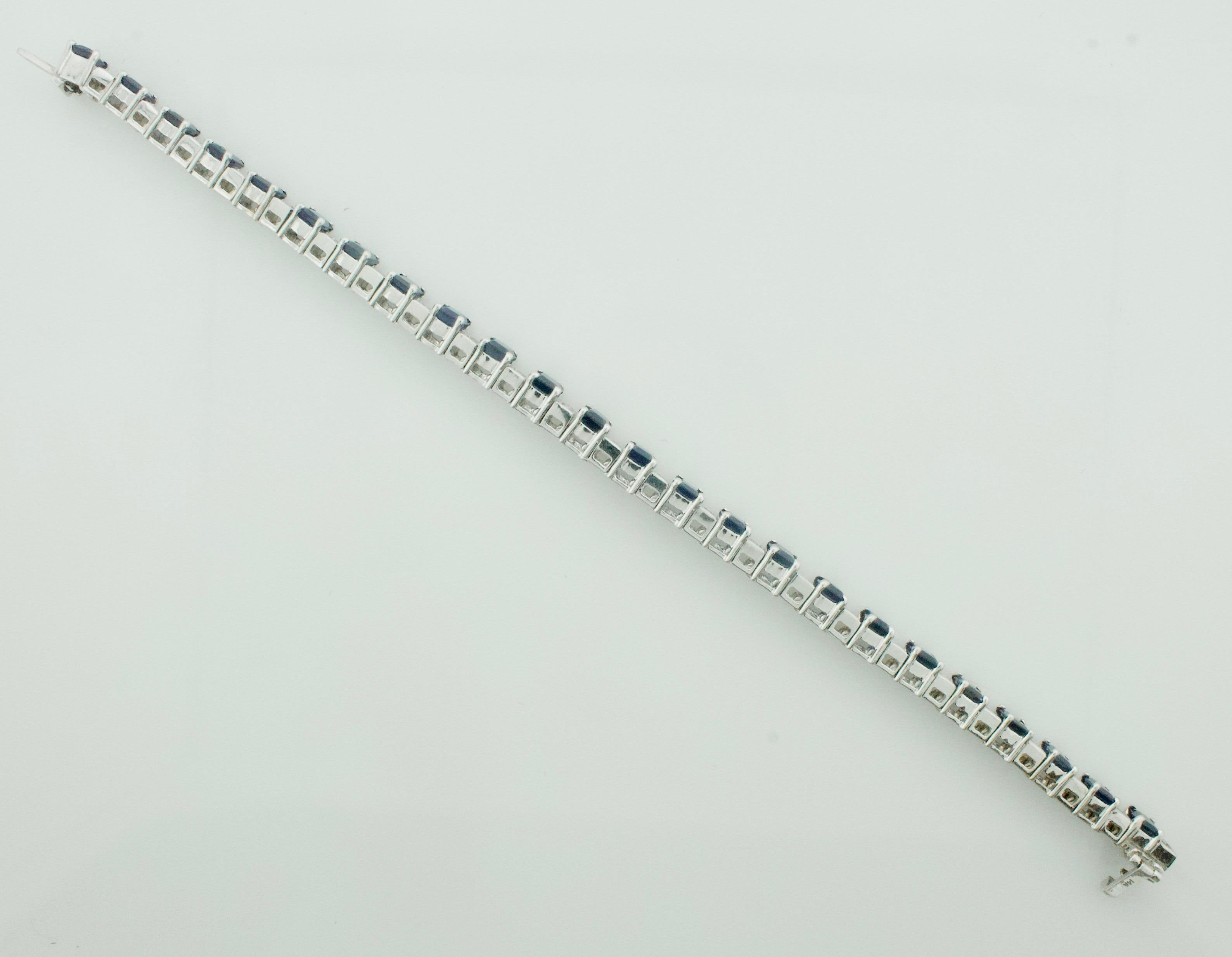 
Step into the realm of opulence with our Emerald Cut Sapphire and Diamond Tennis Bracelet in 18k gold, a masterpiece of timeless elegance. This bracelet is a symphony of luxury, featuring 24 stunning emerald-cut sapphires, each boasting a deep blue