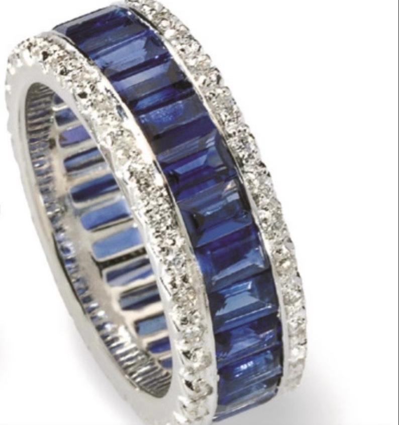 18K white gold ring set with Emerald cut sapphires with 2 rows of round diamonds on the top and bottom of the band. The sapphires are Ceylon. The ring is a size 5.