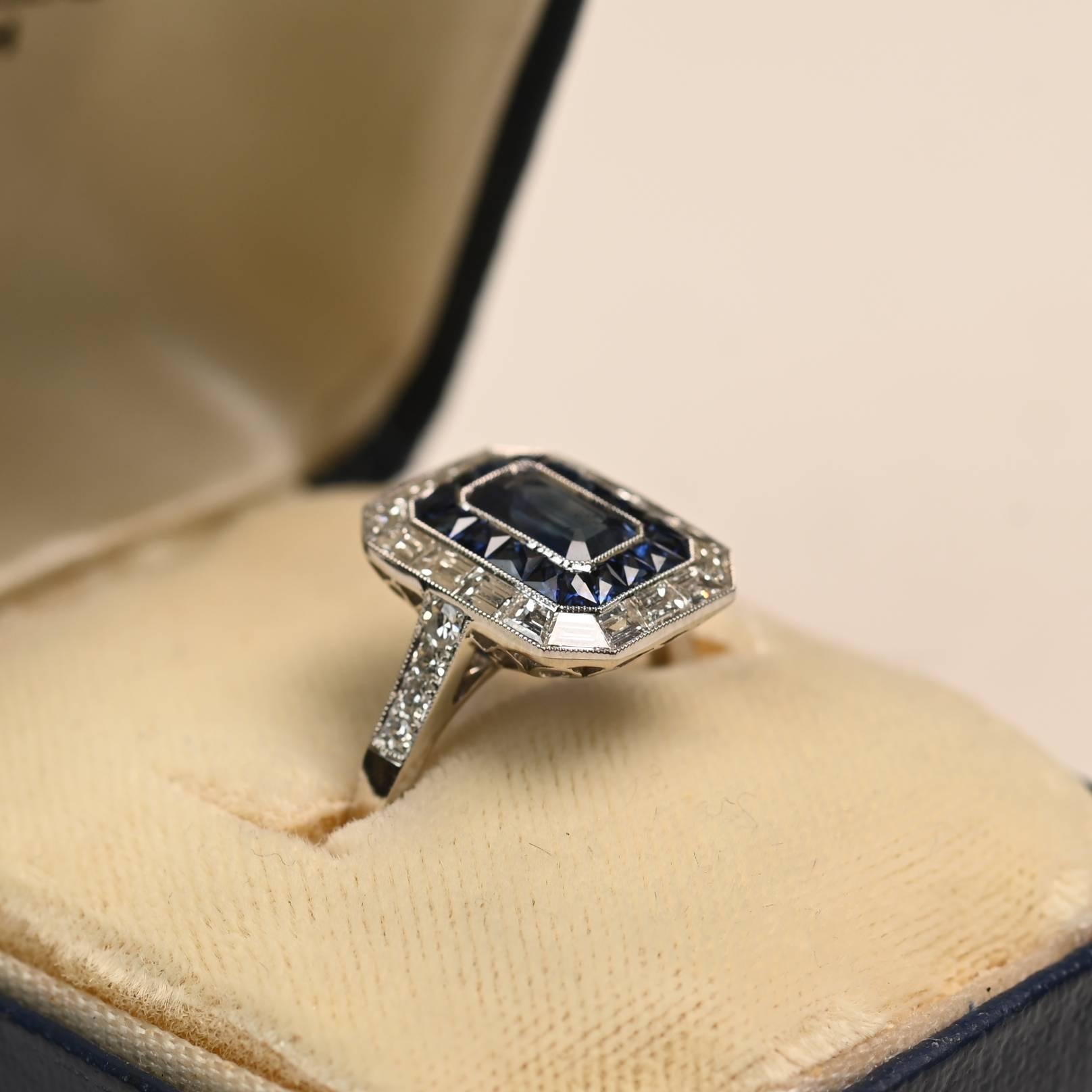 Un sorprendente anello in platino con uno zaffiro taglio smeraldo di circa 0,80 carati, certificato come non caldo e incastonato in una raffinata montatura. La pietra centrale è incorniciata da un audace design a doppia aureola: l'aureola interna è