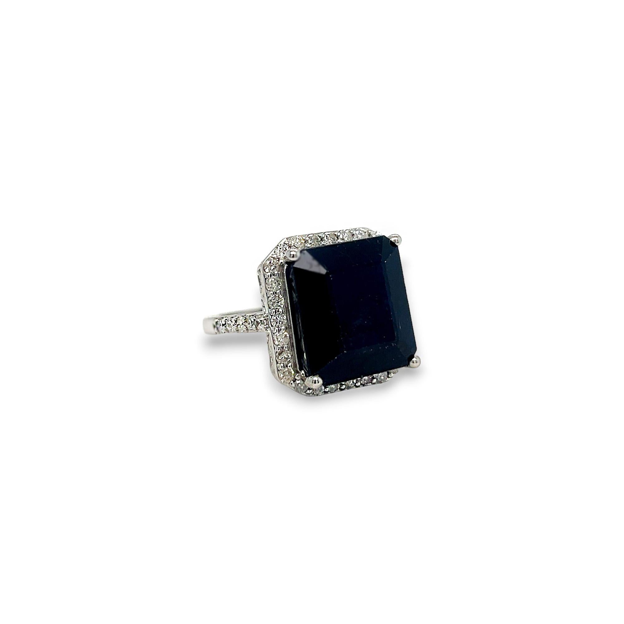 This gorgeous statement ring features a beautiful 17.51 carat emerald cut sapphire center stone and a halo of round diamonds. The side diamonds on the band as well as those that comprise the halo are 1.05 carats total weight, H/I color, and SI