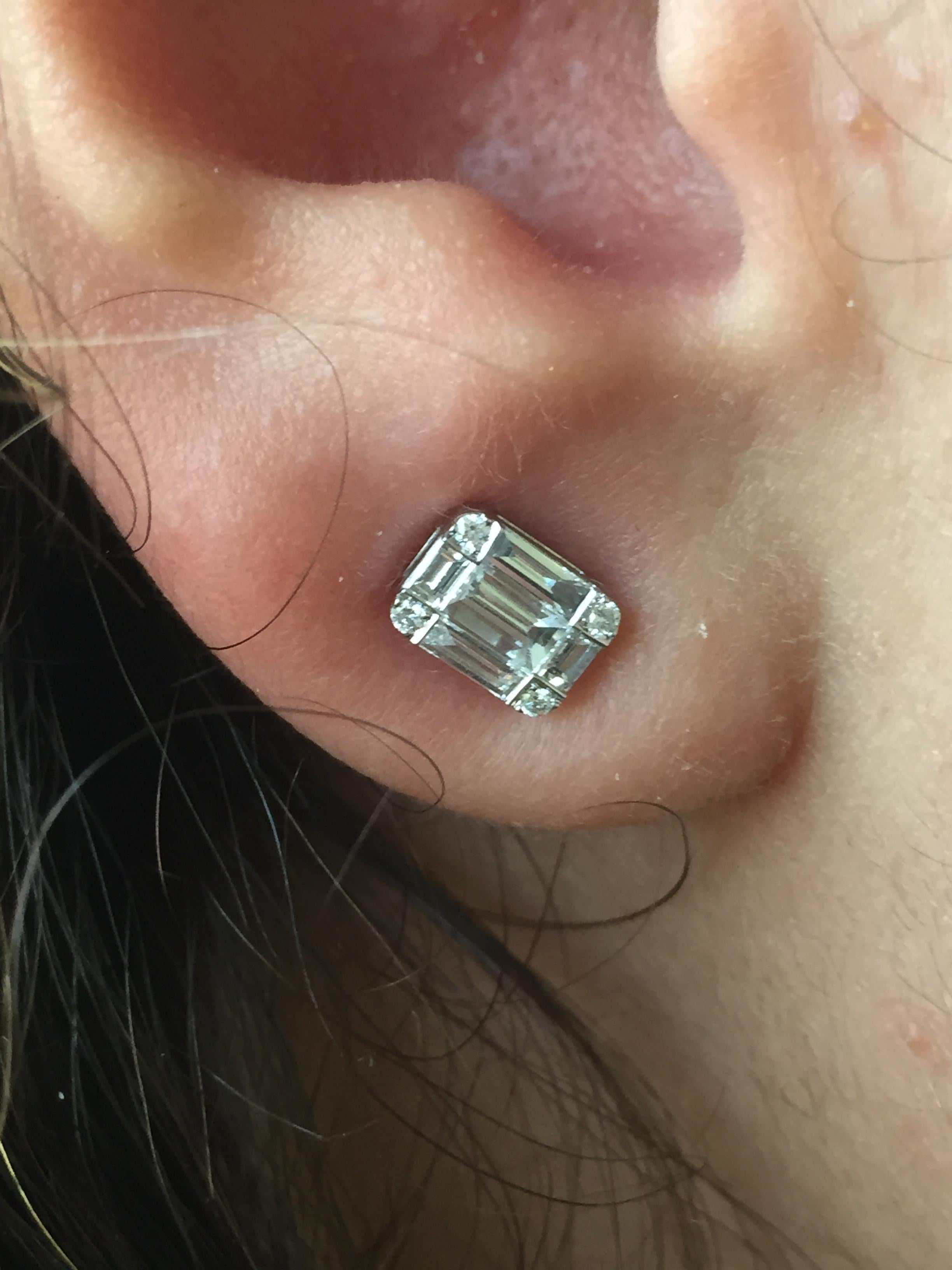 These pair of studs is a combination of baguette and round stones, creating an illusion of a single 2.50 Carat emerald cut diamond. The total diamond weight is 2.25 carats. These earrings are set in 18k White Gold, Color F, Clarity VS.