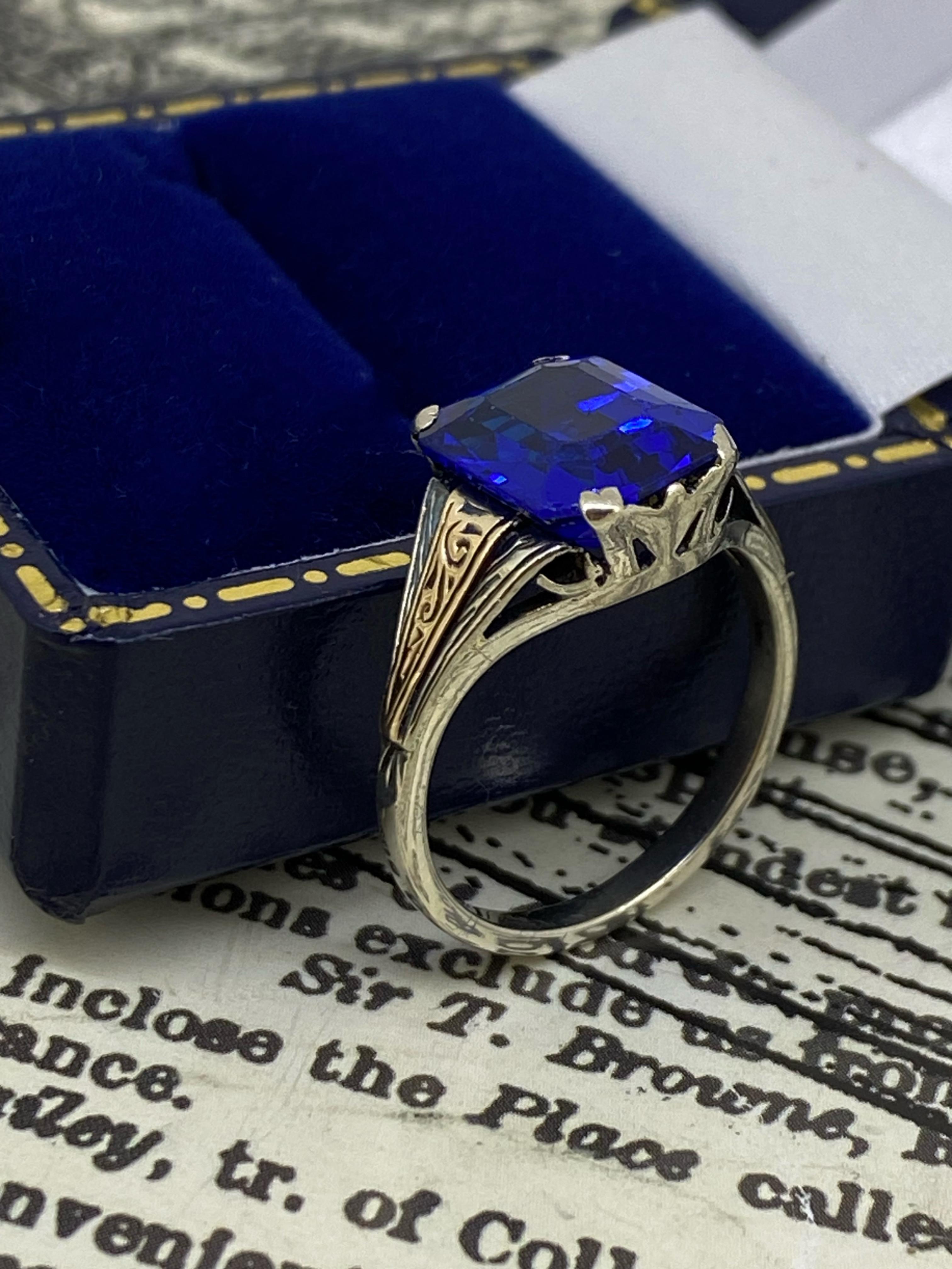 Dating back to early 1950's, 
this retro piece is in remarkable condition 

Performed in Two-Tone 9K Gold 
the ring is centring a Synthetic Sapphire 
of superb vivid Royal Blue colour, 
of highly desirable emerald cut, 
measuring 10.5mm x