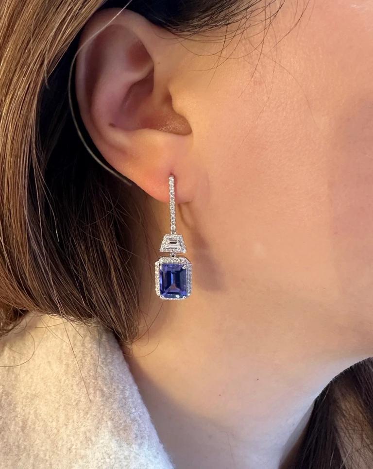 Emerald Cut Tanzanite and Diamond Drop Earrings in 18k White Gold

Diamond and Tanzanite Earrings features 2 Emerald cut Tanzanite weighing 6.61 carats surrounded by one row of Round Brilliant Diamonds. Each earring top has a single Diamond
