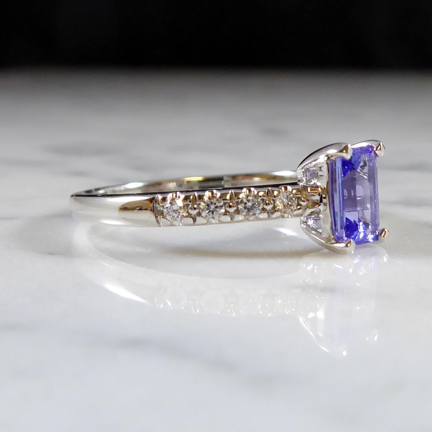 A beautiful tanzanite and diamond ring perfect for an engagement ring or dress ring for the petite hand.  The rectangular shaped tanzanite measuring 6.0mm x 4.0mm is set in four white claws to an open rectanglar mount to diamond set shoulders.  Each