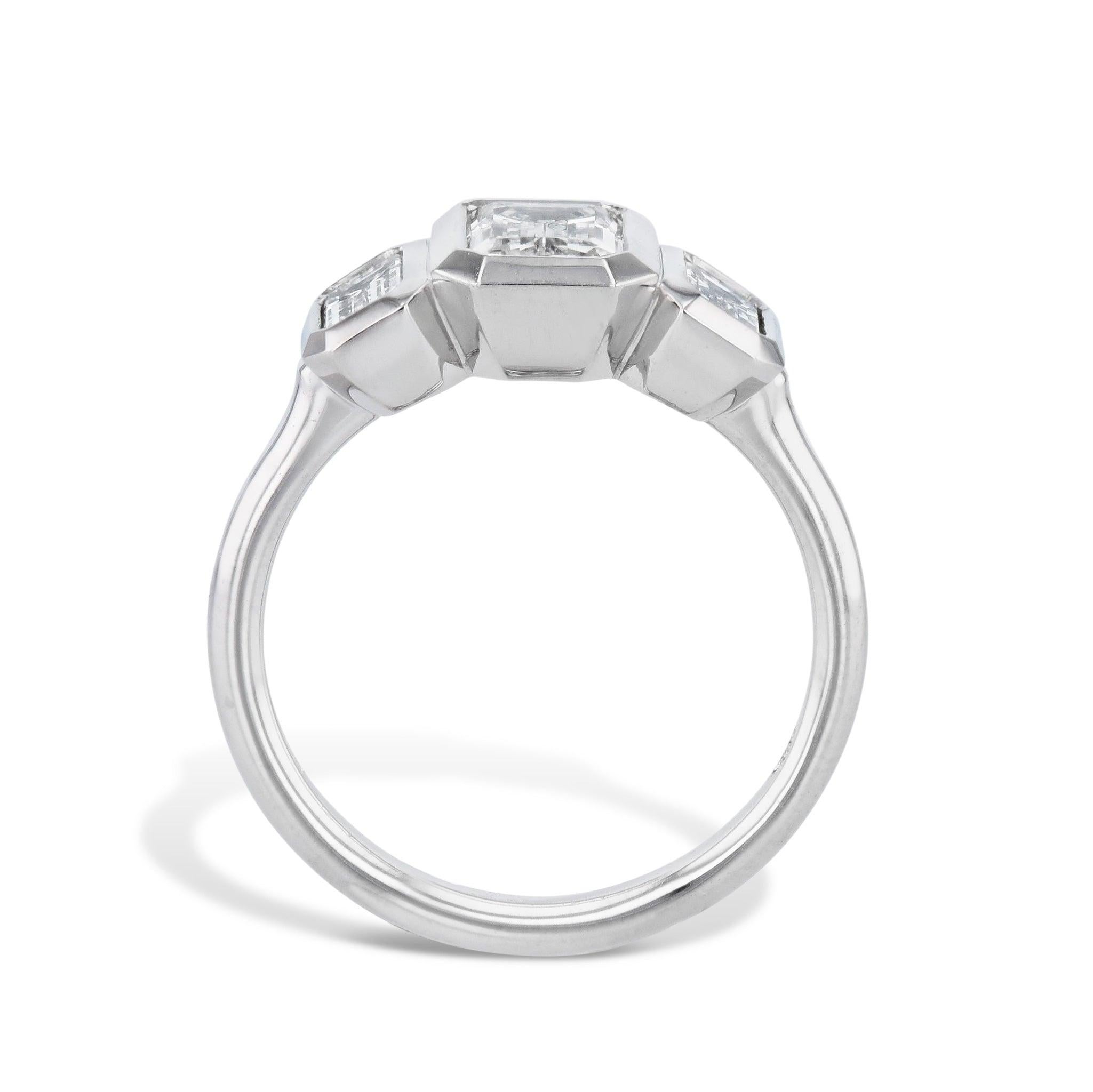 This precious engagement ring features a brilliant Emerald cut diamond set in pure platinum. Flanking the center diamond are two stunning emerald cut diamonds. Handmade from the H&H Collection. Fall in love with this Emerald Cut three Diamond