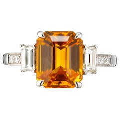 Anello con zaffiro giallo-arancio taglio smeraldo e diamanti baguette in oro 18 carati