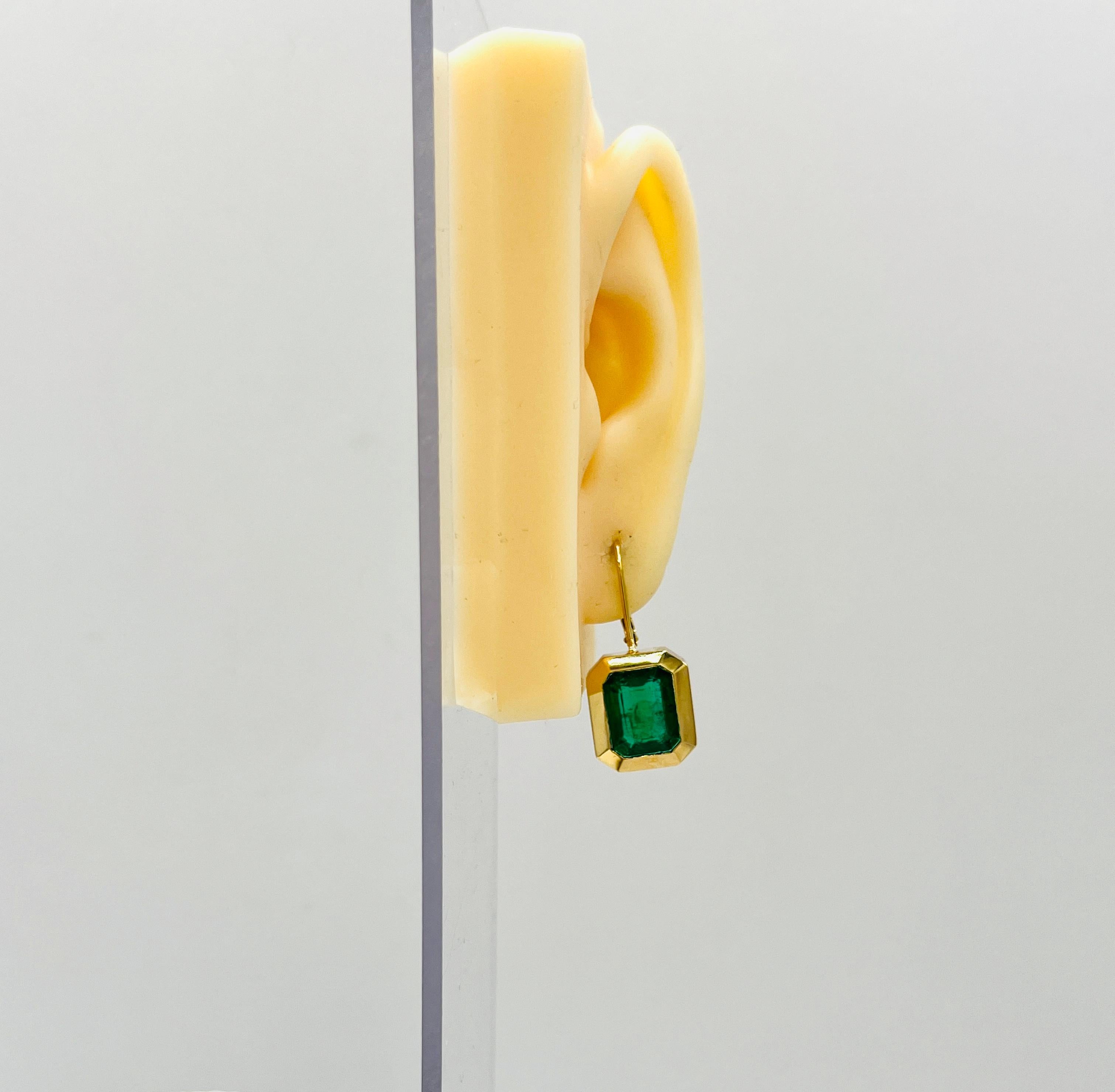 Beautiful emerald earrings with 11.00 ct. good quality emerald cut emeralds in a handmade 18k yellow gold bezel.  