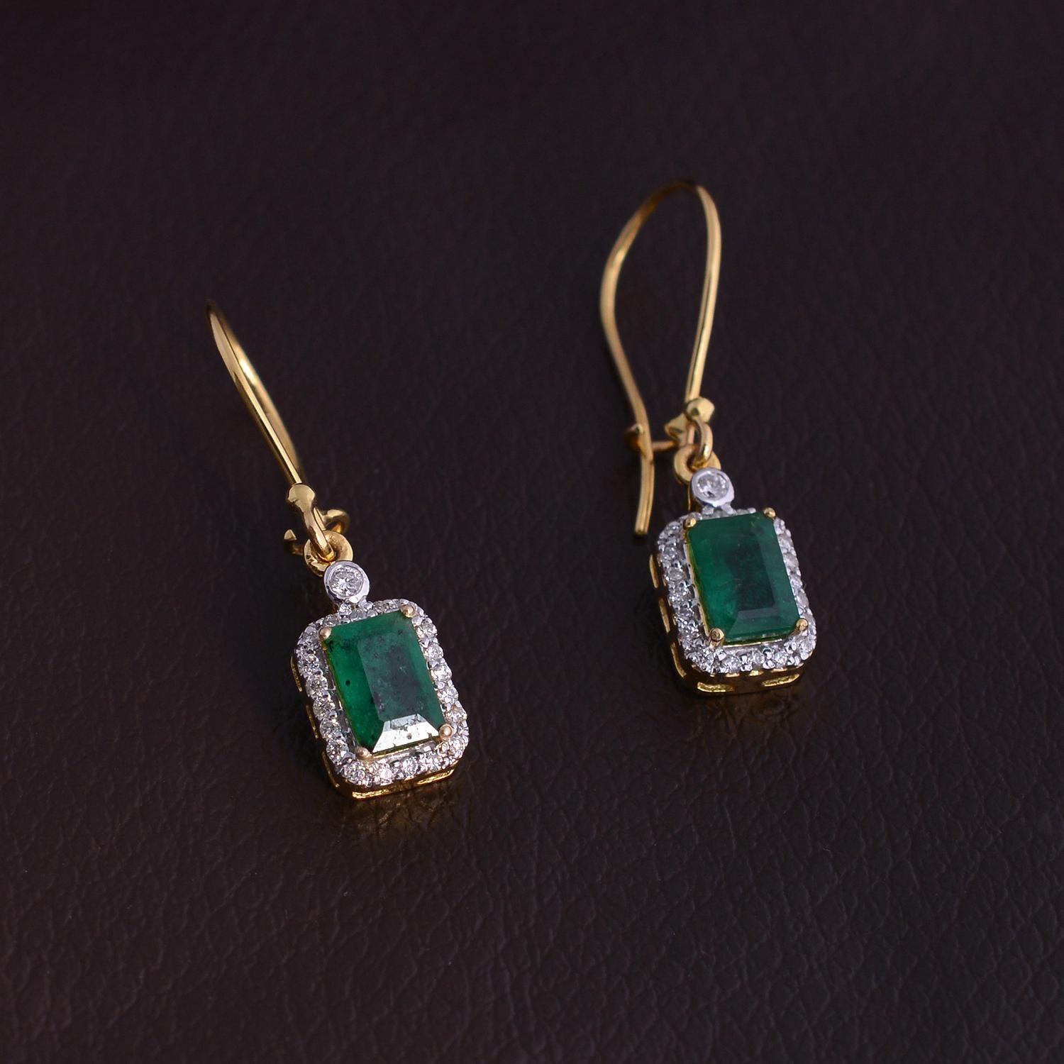 Impressive emerald gemstone dangle earrings set in 14kt yellow gold with natural diamonds.  A perfect addition to any ensemble.  

Specifications

Dimensions: 30X7 MM
Gross Weight: 2.61 gms
Gold Weight: 2.98 gms
Gold Purity: 14K Yellow Gold
Diamond