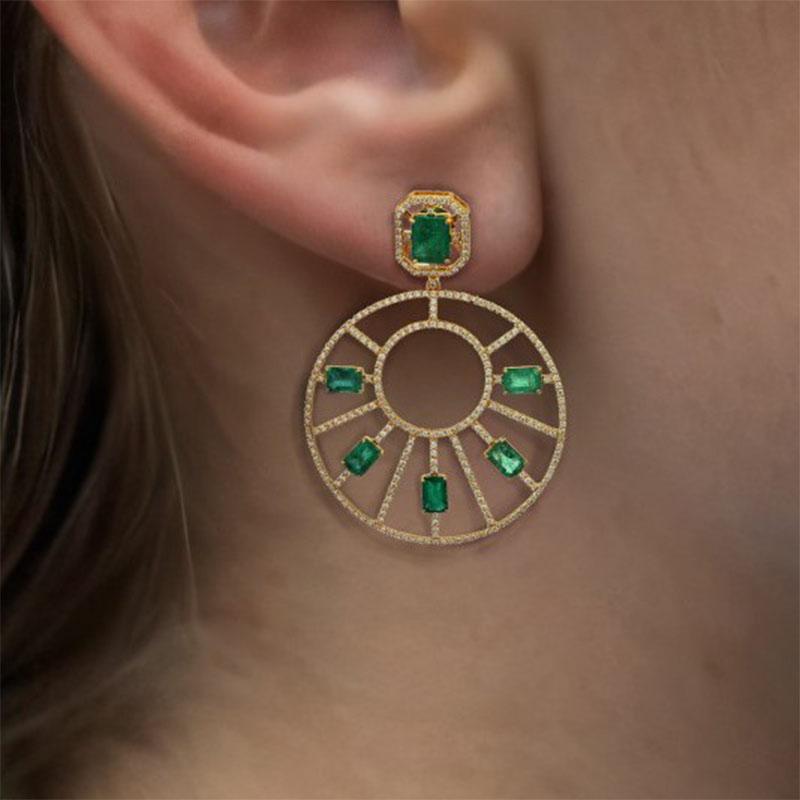 Fai una dichiarazione audace con questi orecchini con diamante smeraldo in oro giallo 14K, caratterizzati da 3,38 carati di diamanti radianti e 8,22 carati di smeraldi vibranti. Realizzati in un lussuoso design da 15 grammi, questi orecchini offrono