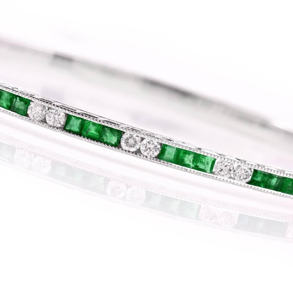 This Art Deco design bangle bracelet of notable feminine grace is crafted in solid 18-karat white gold, weighing 19.2 grams and measuring 7.5 inches around the wrist. The enchanting bracelet is enriched with 21 channel-set square-cut emeralds