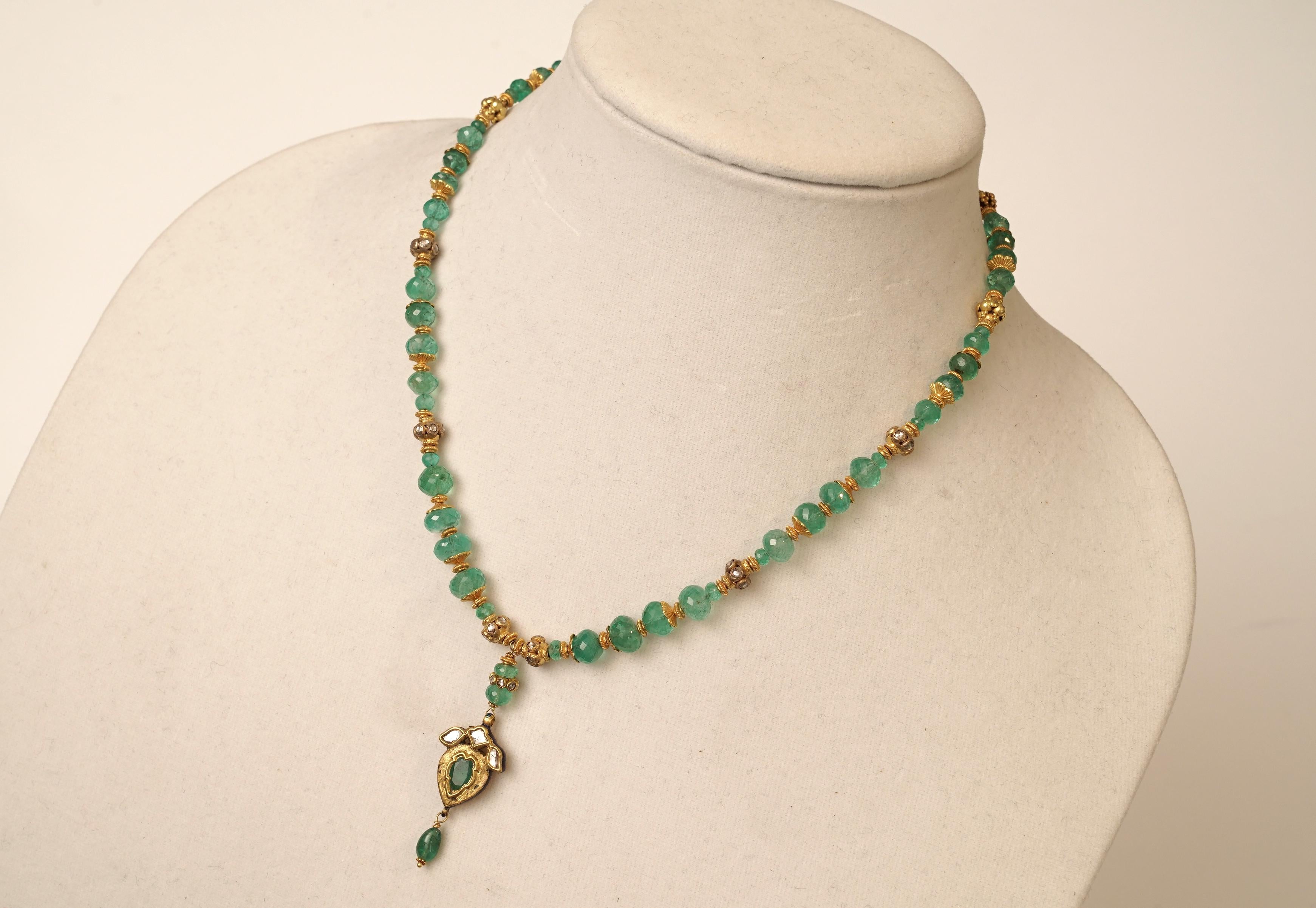 Faceted, round Columbian emerald beads with excellent clarity and color with 22K gold end caps and spacers along with 22K gold diamond rondelles.  The necklace features a long pendant with a pear-shaped, rose-cut emerald and rose-cut diamonds set in
