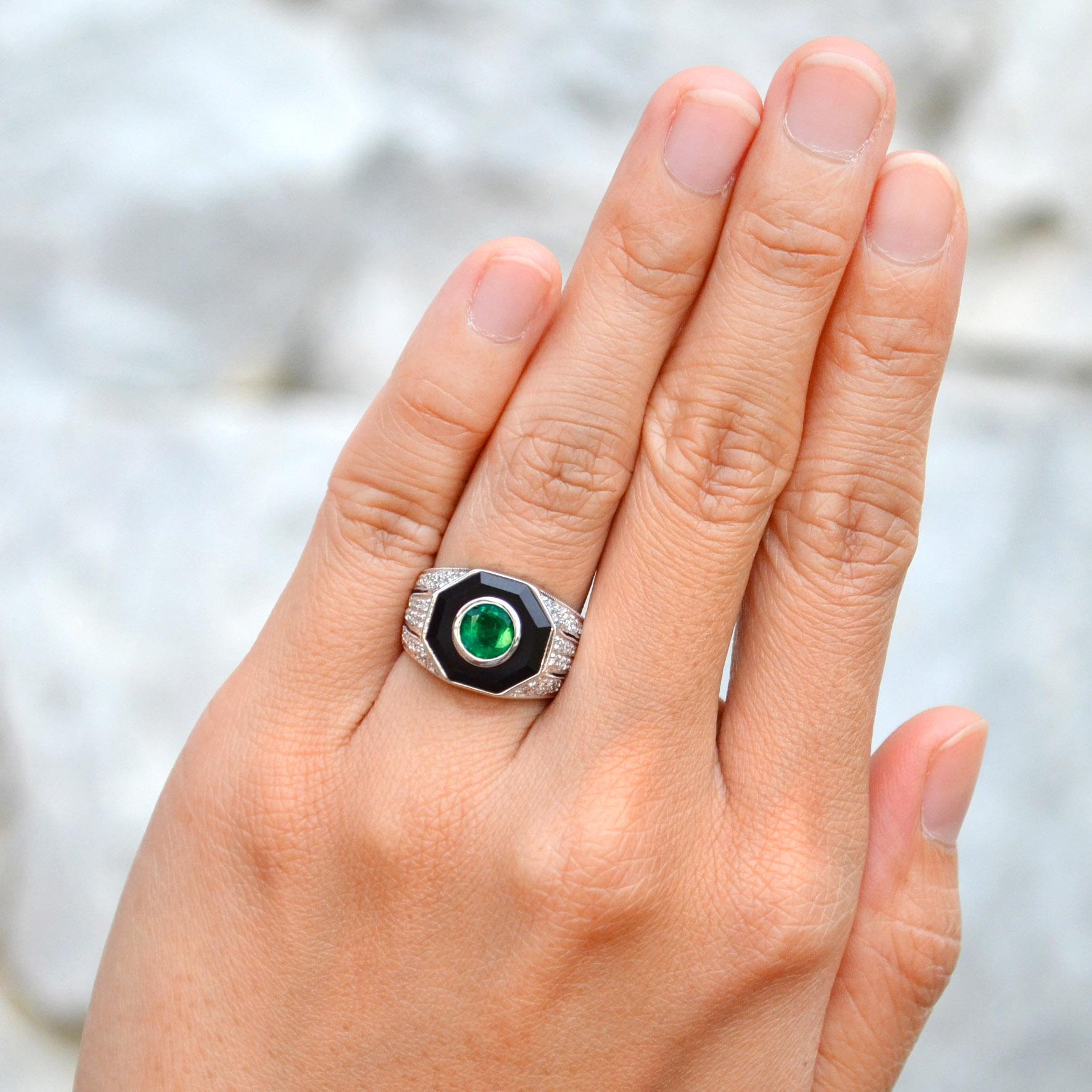 This Emerald, Diamond, and Onyx Art Deco-style dome ring in 14K white gold is a bold and captivating statement piece. The rich, vibrant emerald at the center is surrounded by a striking contrast of black onyx and sparkling diamonds, creating a