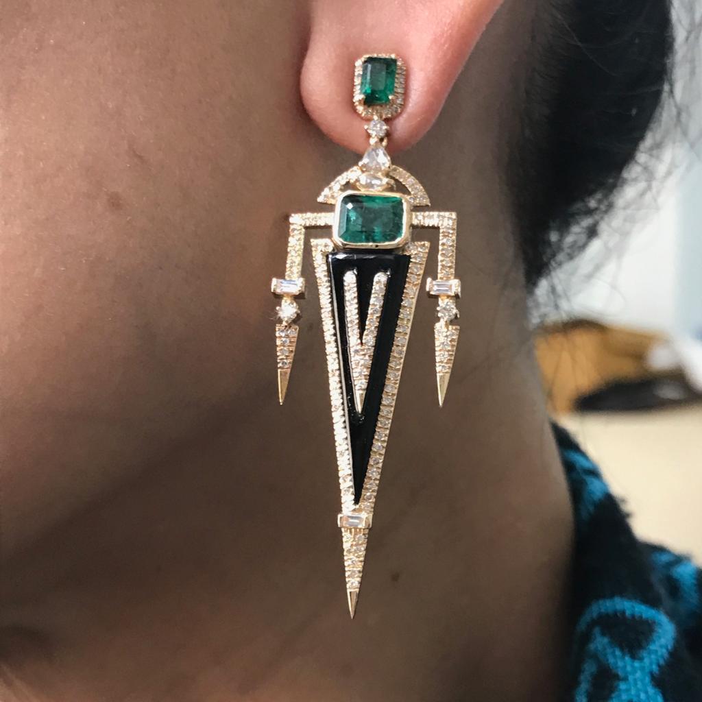 A beautiful pair of art-deco looking earrings. Consists of Zambian Emeralds, White Diamonds and Black Onyx, all set in 18K Yellow Gold, with push pull backing. 