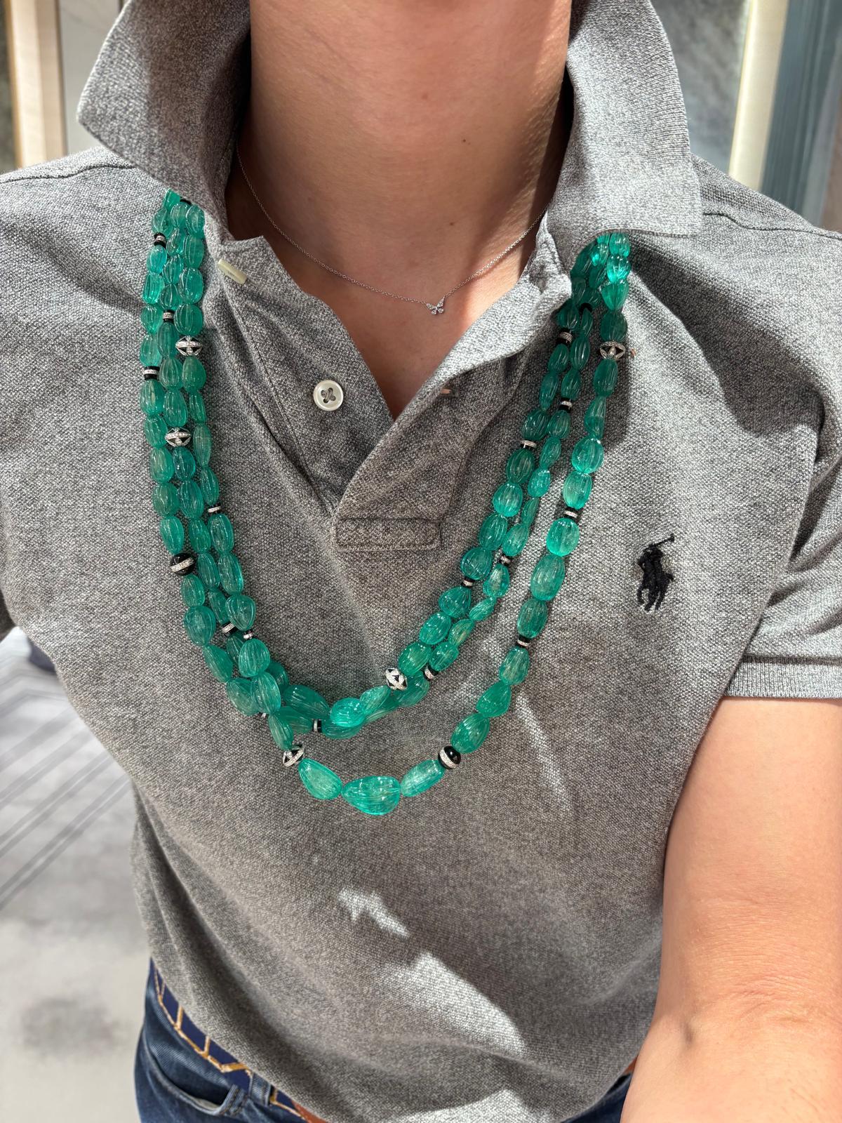 Un'importante collana a tre file di perline con smeraldi, diamanti e onice della lunghezza di 30 pollici. Questa collana, che ricorda le grandi collane di smeraldi scanalate dell'Art Déco, presenta ben 887 carati di smeraldi e 9,77 carati di