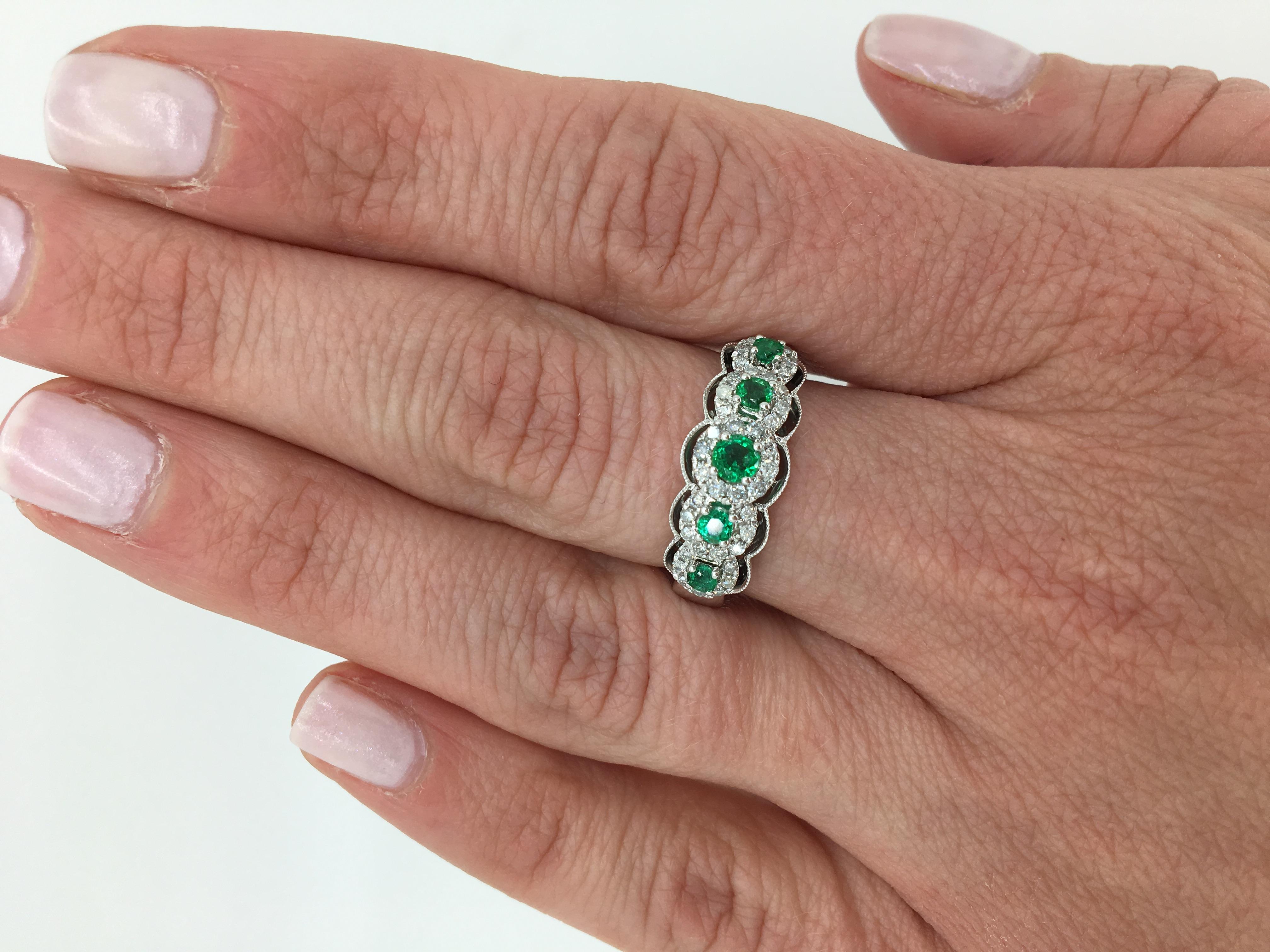 Halo style emerald and diamond band ring crafted in 14k white gold.

Gemstone: Emerald & Diamond
Gemstone Carat Weight: Approximately .46CTW Round Cut Emeralds
Diamond Carat Weight: Approximately .32CTW
Diamond Cut: Round Brilliant 
Color: Average