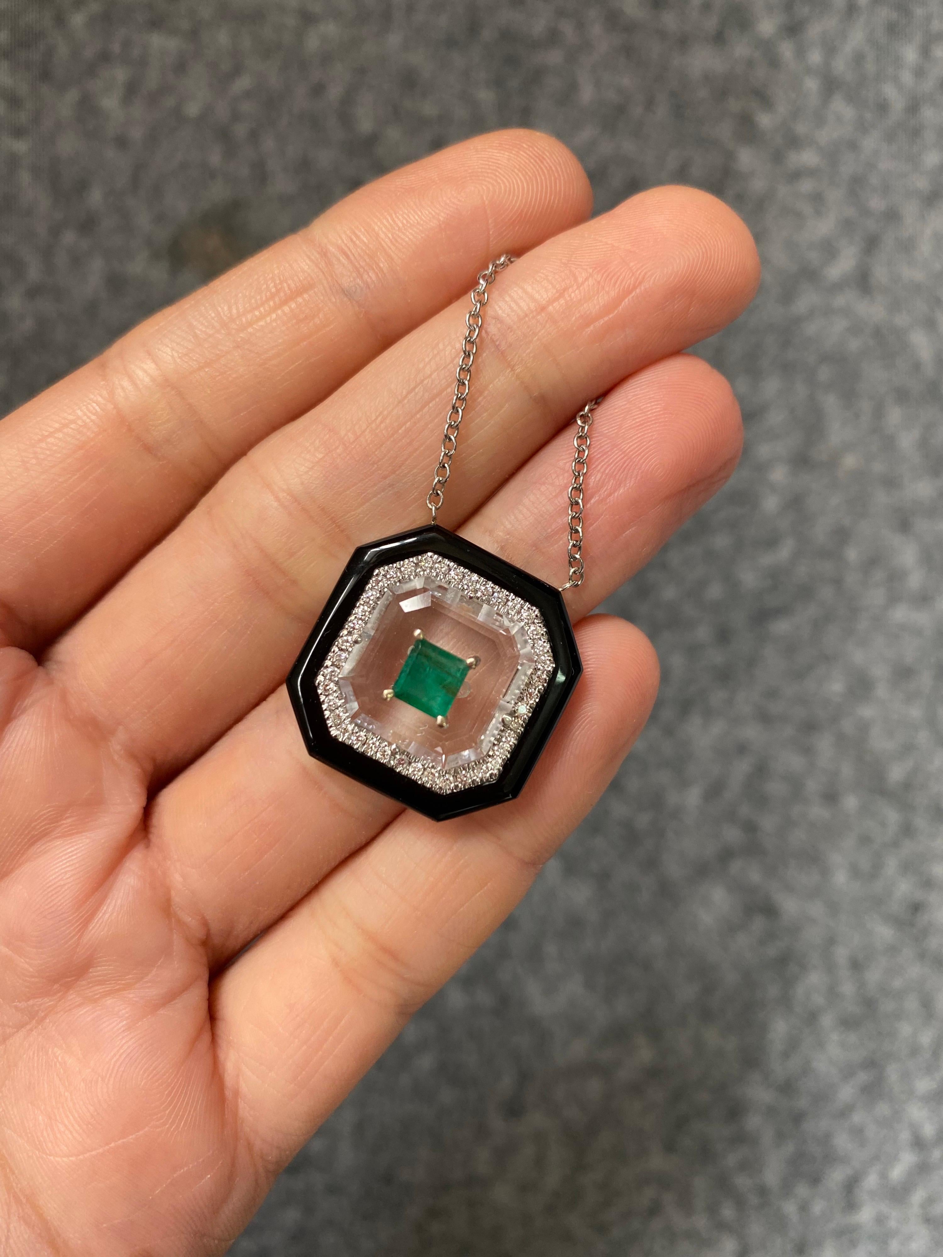 Ein Anhänger im Art-Deco-Stil mit einem sambischen Smaragd von 0,62 Karat, weißen Diamanten von 0,29 Karat, Bergkristall und schwarzem Onyx, alle in massivem 18-karätigem Weißgold gefasst. Die Länge der Kette beträgt derzeit 18 Zoll, kann aber