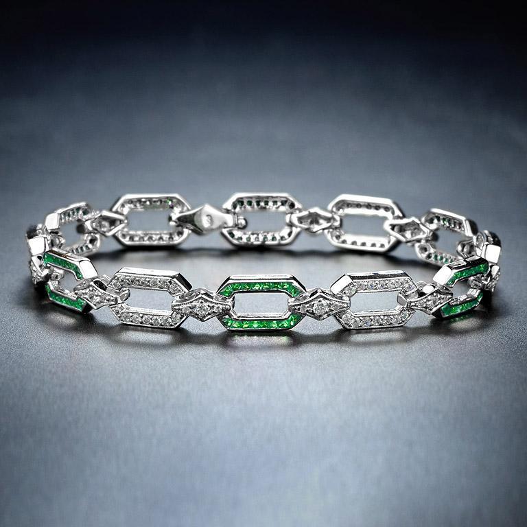 Featuring dazzling diamonds and emeralds, this Art Deco-style bracelet is beautifully made. It is geometric in design and symmetrical. The diamonds are a total weight of 1.50 carat approximately and are estimated as G in color and VS in clarity.