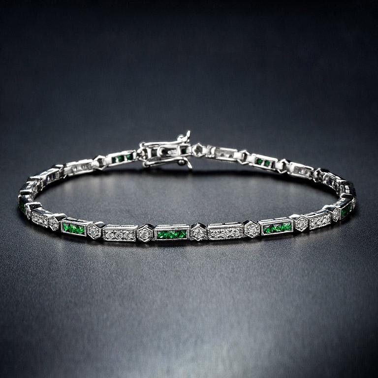 Dieses luxuriöse und farbenfrohe Armband von Aimée ist abwechselnd mit einem dreifachen Smaragd im französischen Schliff und runden Diamanten im Brillantschliff besetzt. Das 18-karätige Weißgold verleiht dem klassischen Art-Deco-Stil Sicherheit, und