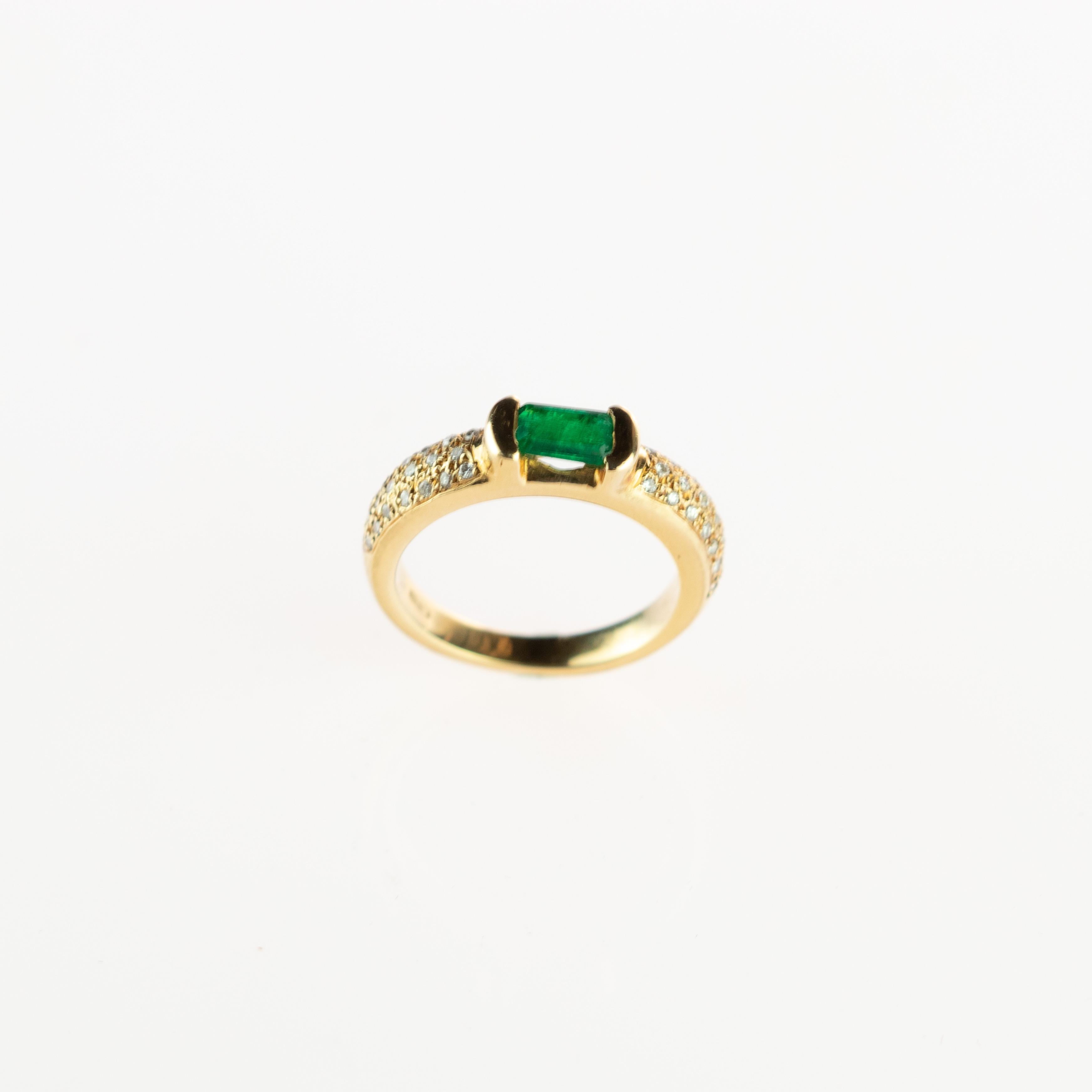 Amazing and stunning 0.52 carat emerald stone with a brilliant cut that is surrounded by 18 karat yellow gold. Embellished by numerous diamonds that create an elegant cocktail jewel piece enhanced by a solitaire look in a unique way. 
 
This ring is