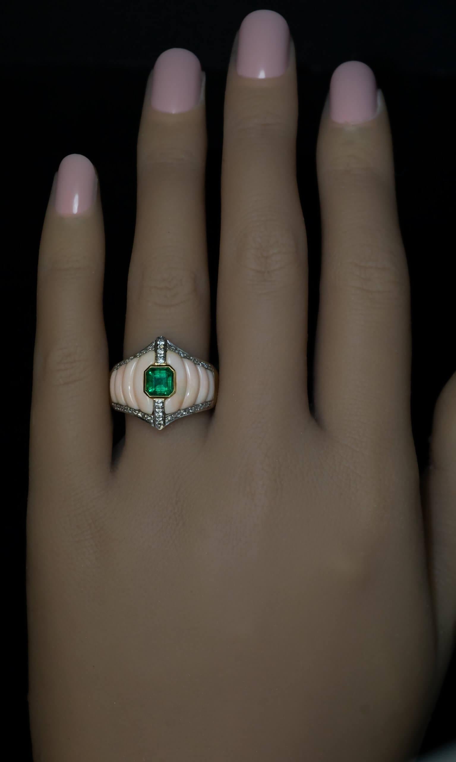 Italien, ca. 1970er Jahre  Ein eleganter und einzigartig gestalteter Ring aus 18 Karat Gelbgold, in dessen Mitte ein exzellenter Smaragd von lebhafter bläulich-grüner Farbe liegt. Der zentrale Stein wird von zwei skulpturalen, beigefarbenen,