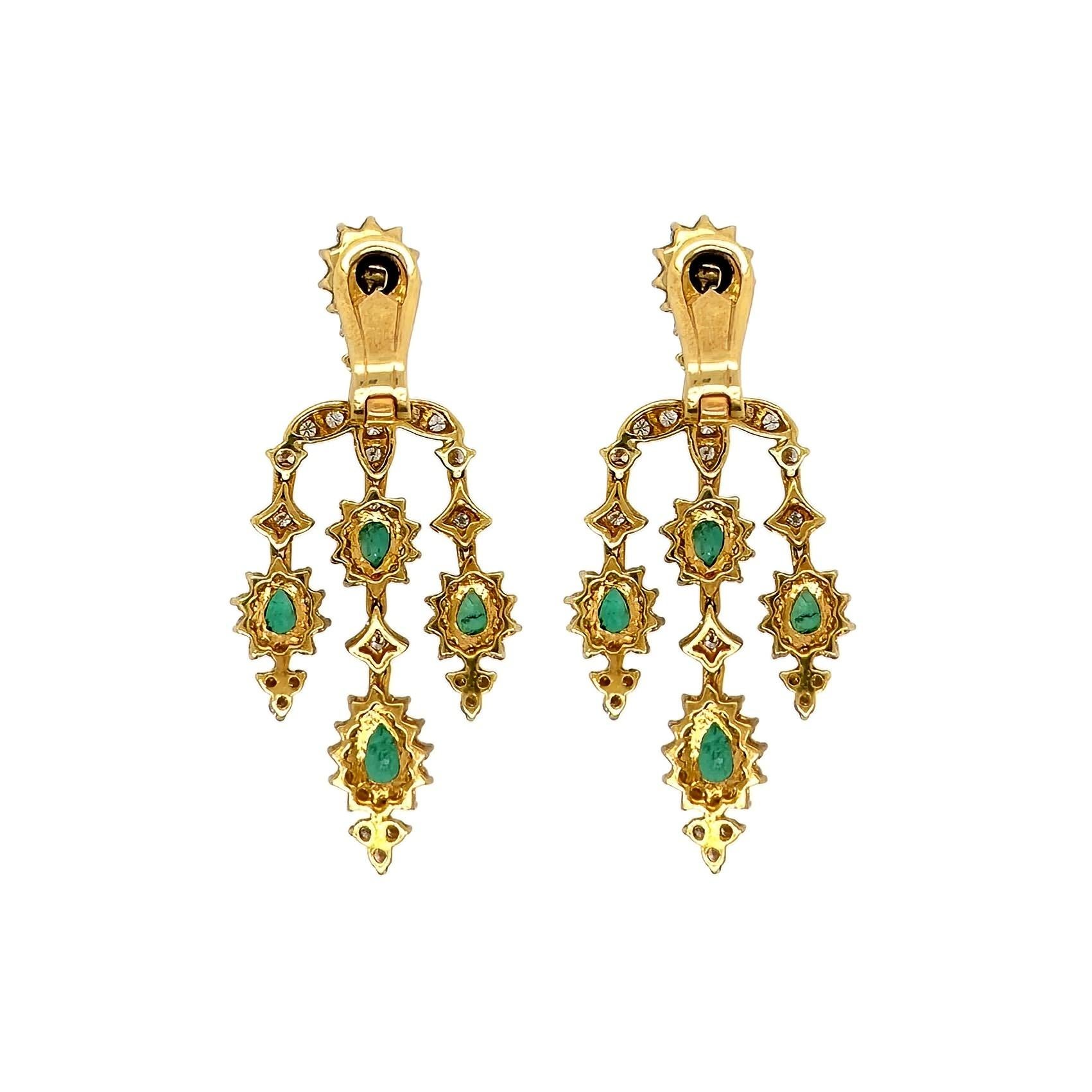 Un par de pendientes de oro amarillo de 18 quilates, esmeraldas y diamantes.  Cada pendiente estilo araña está diseñado como una esmeralda facetada en forma de pera rodeada de diamantes talla brillante redondos sobre un triángulo de diamantes talla