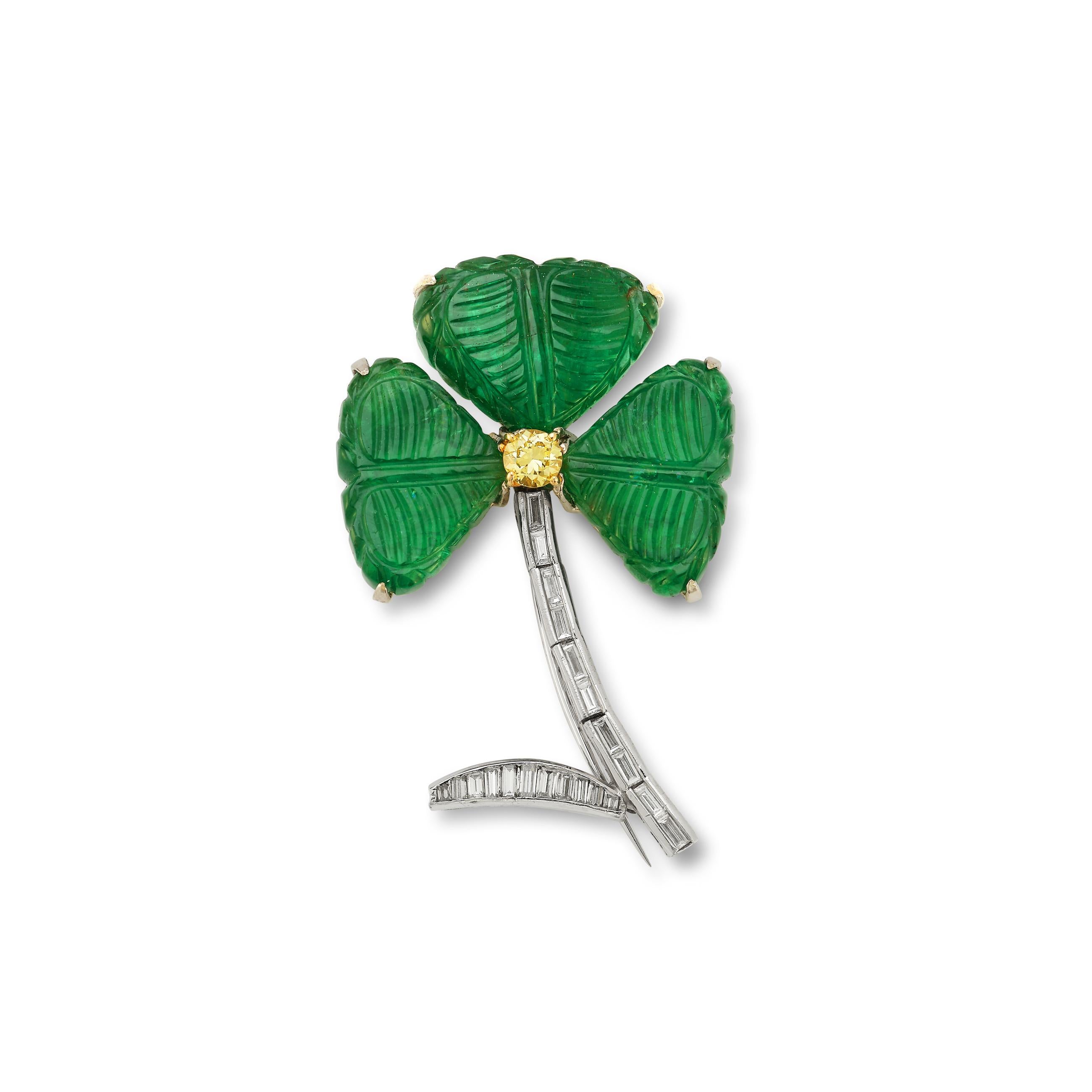 Emerald & Diamond Clover Flower Brooch

3 carved emeralds surrounding 1 round cut yellow diamond, and Baguette cut diamonds as a stem and leaf. 

Emerald Weight: approximately 38.89 cts 

Center Round Colored Diamond Weight: approximately .40 cts