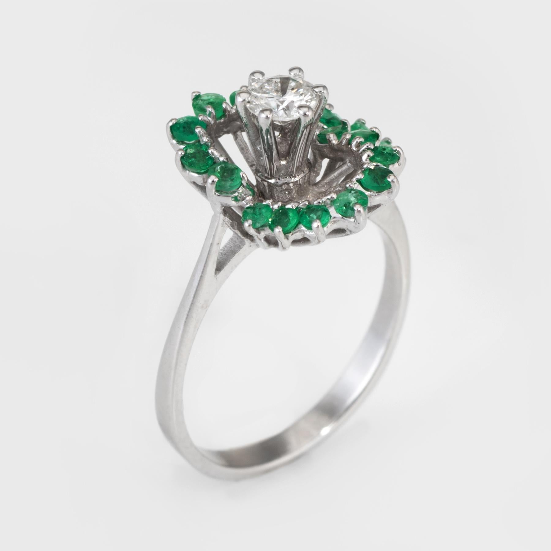 Finely detailed vintage cocktail ring, crafted in 14 karat white gold. 

Centrally mounted estimated 0.25 carat round brilliant cut diamond (estimated at H-I color and SI2 clarity), is accented with an estimated 0.34 carats of emeralds.     

The