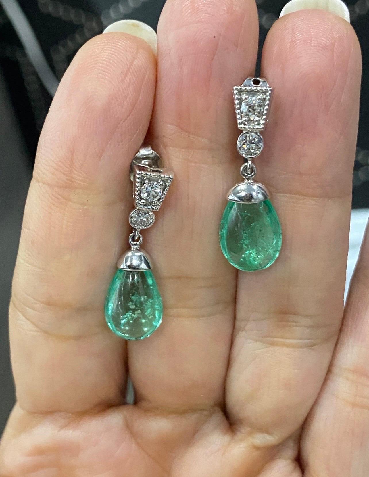 Two Cabochon Emeralds 3.50 and 3.17 CTW dangling from a art deco
bezel set Diamond and post back milgrain detailed stud. Approximately
0.35 CTW. Set in Platinum / White Gold.