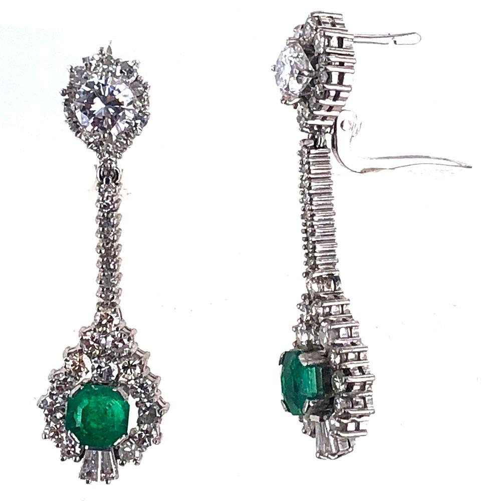 These stunning diamond and emerald drop earrings are crafted in 18 karat white gold. Two round cut emeralds ( 1.60 carat total weight) are set in the drop surrounded by round brilliant cut diamonds. There are approximately 2.75 carat total weight of