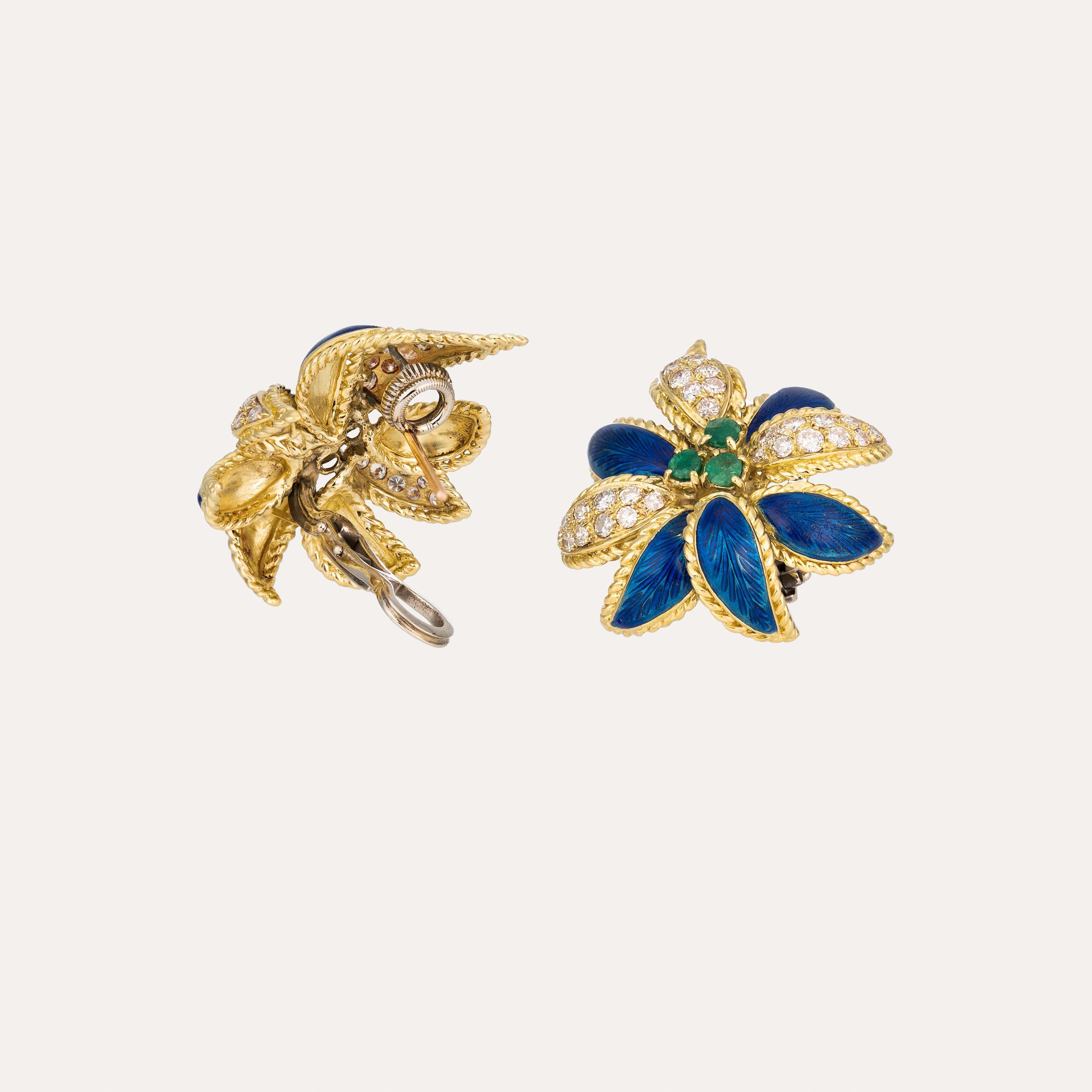 These exquisite emerald diamond enamel yellow gold earrings celebrate the harmony of nature through refined craftsmanship and timeless design. Created in 18 karat yellow gold, the earrings feature a striking floral motif, where deep blue enamel