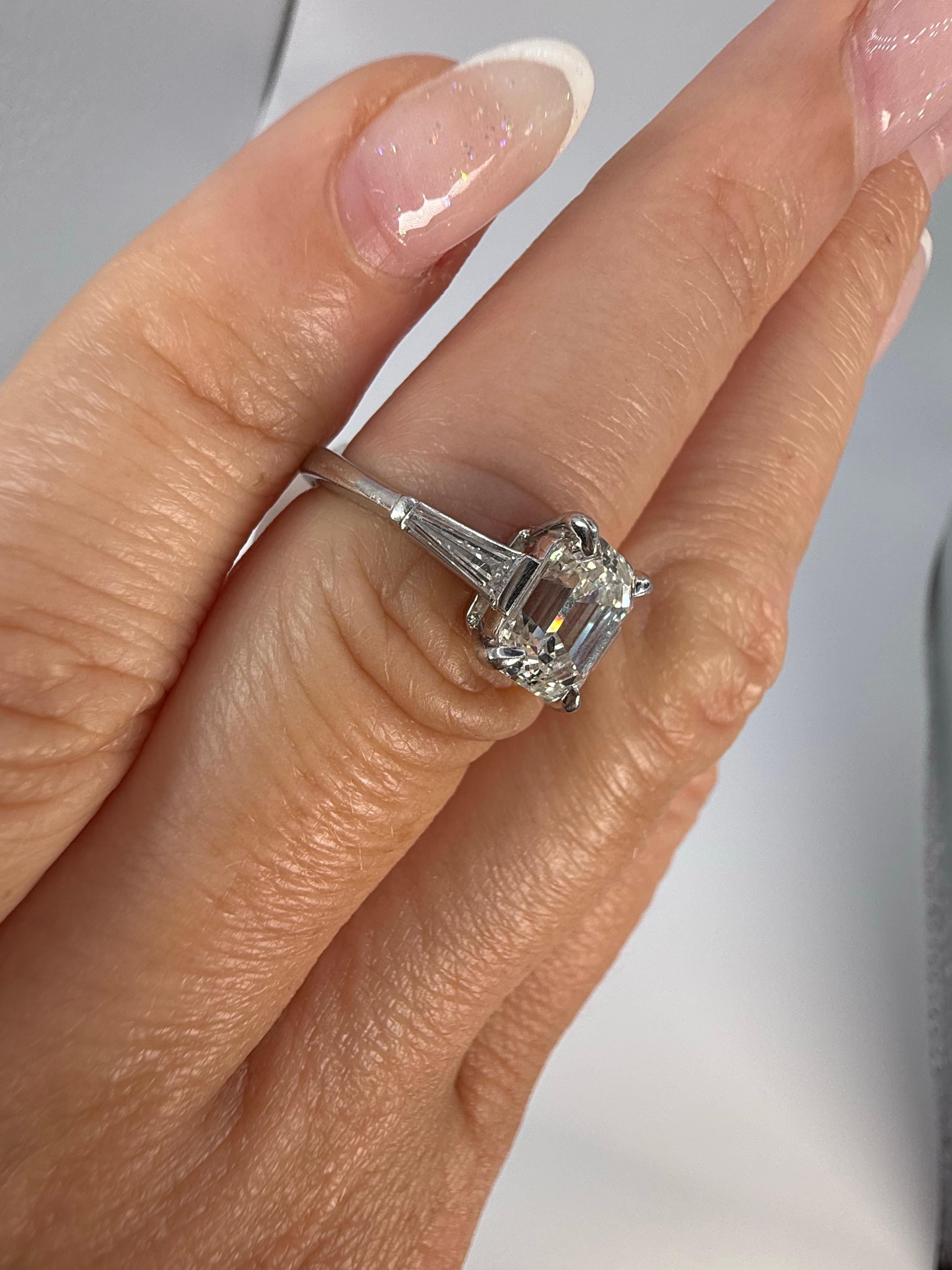 Bague moderne en diamant émeraude en platine, diamant central de 2 carats certifié GIA, pureté SI2, couleur I. La bague est éblouissante, d'une grande pureté et très luxueuse. Les diamants trapézoïdaux latéraux totalisent 0,14 carat.
Article