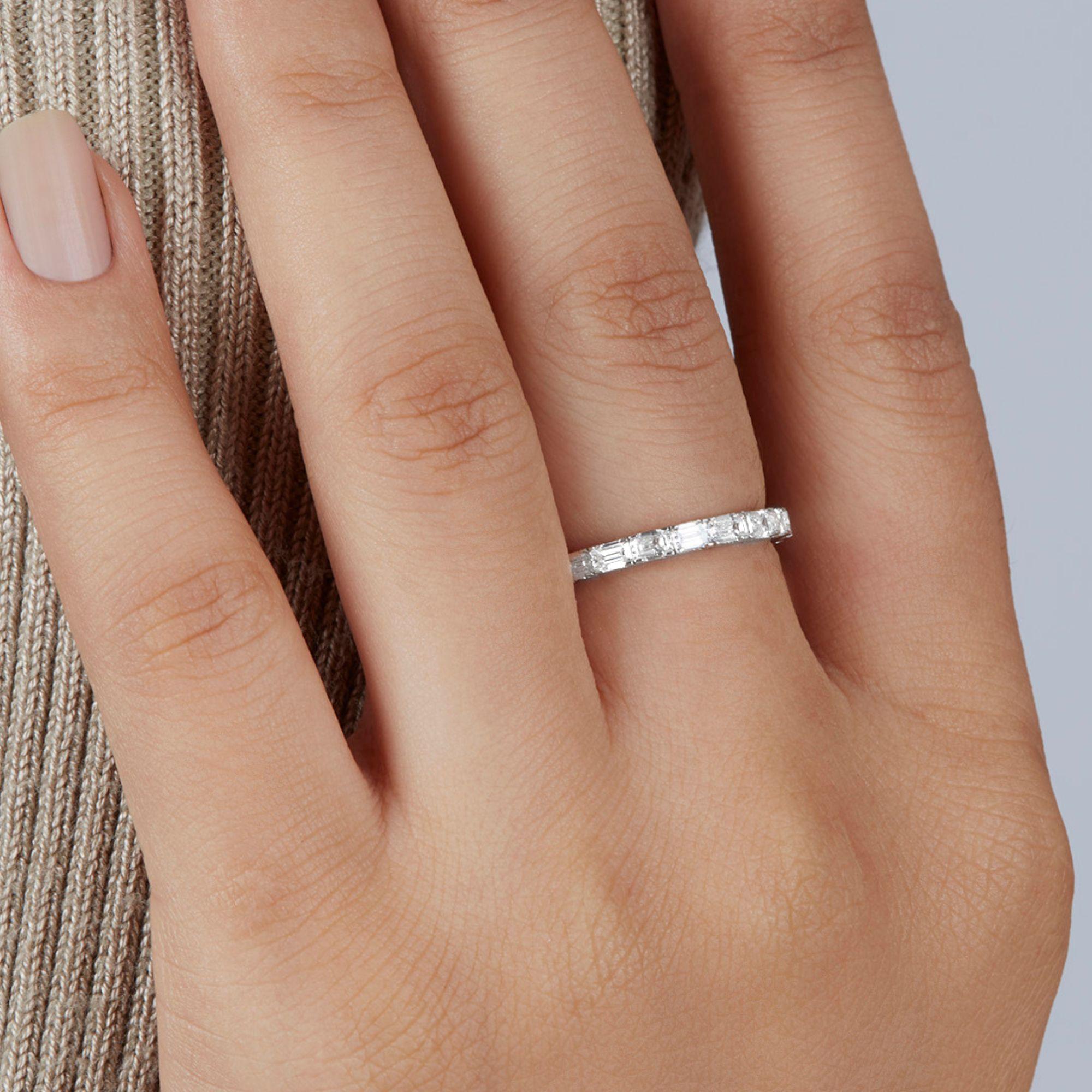 Elevate your wedding stack with our Emerald Diamond Eternity Ring in 14K Gold. Its water-like sparkle adds shine and dimension. The low profile makes it easy to stack, while the shimmering emerald cuts catch light beautifully—even when worn on its