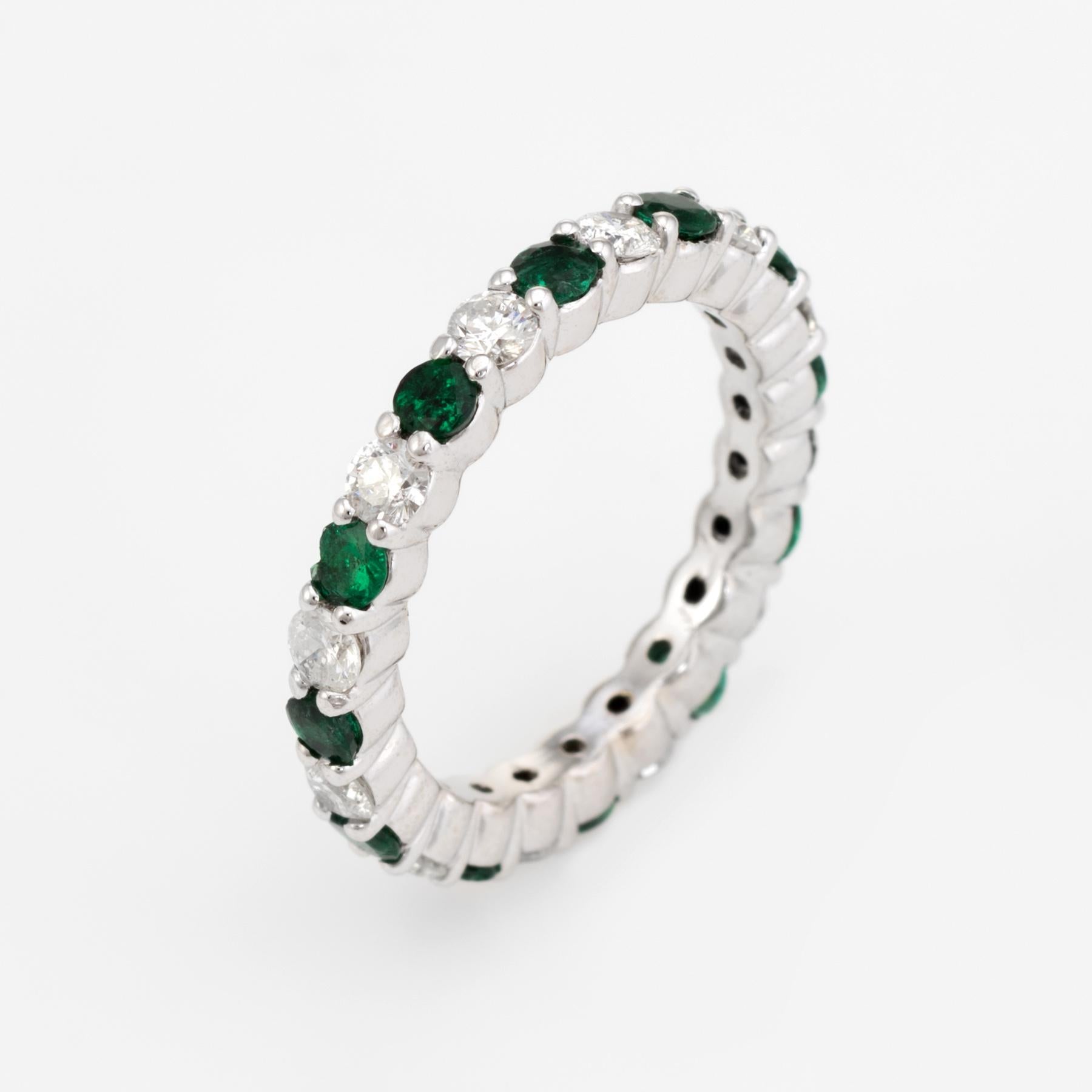 Elegant estate eternity band, crafted in 14 karat white gold. 

Round cut emeralds total an estimated 1 carat, accented with an estimated 1 carat of diamonds (estimated at H-I color and VS2-SI1 clarity). 

The ring is in excellent condition.