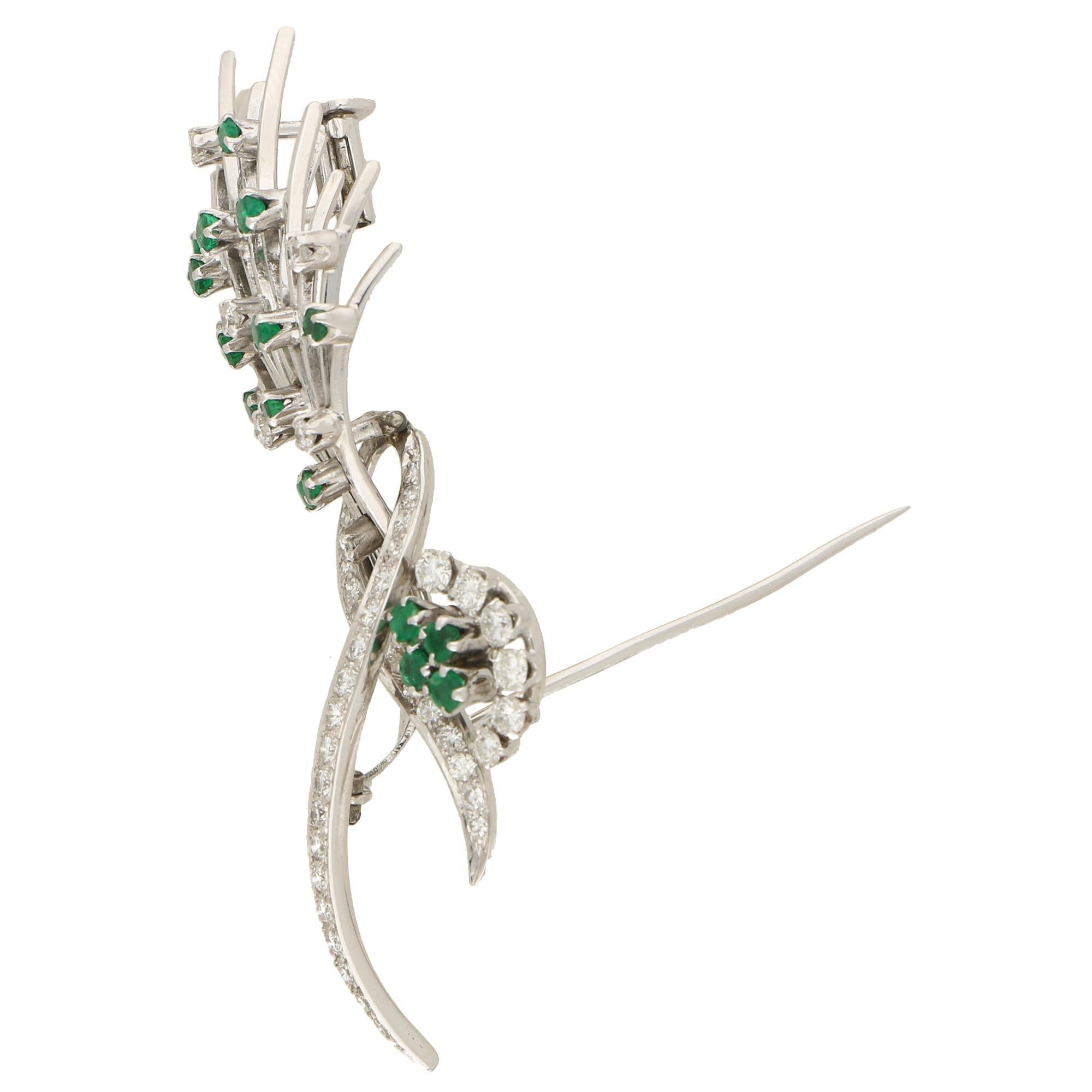 A beautiful vintage emerald and diamond floral spray brooch set in platinum. The brooch is estimated to be from the 1980's and is set with bright round cut emeralds and round brilliant cut diamonds. These stones are set amongst a floral spray of 15