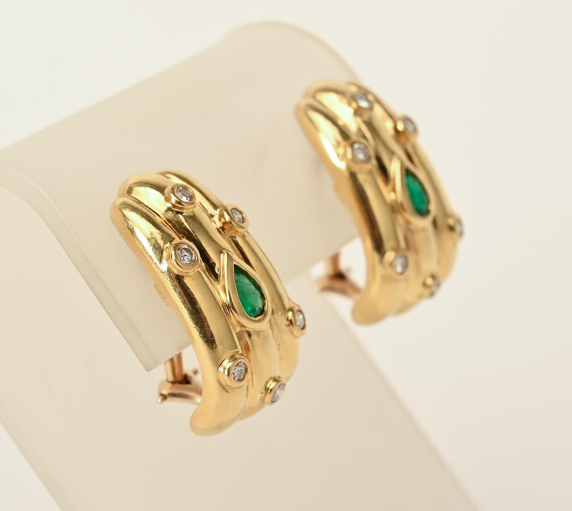 Substantial size 18 karat gold earrings with three ribs centered with a pear shaped emerald and surrounded by 6 round diamonds. Omega backs. Maker's mark JDI.