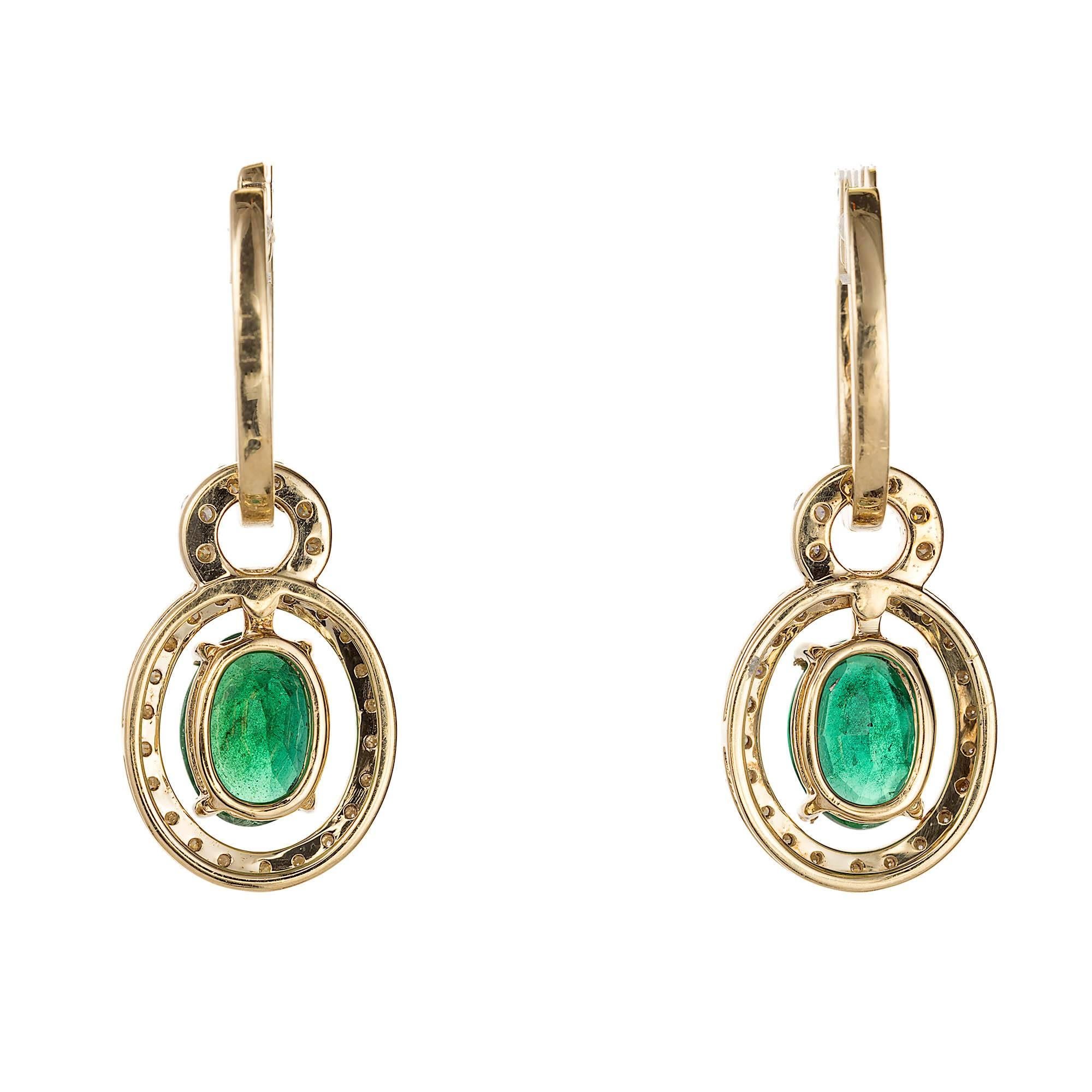 Beautiful huggie style diamond earrings in 14k yellow gold with removable Emerald and Diamond dangle sections. The diamonds are full cut, . The oval emeralds are deep green and bright. They have moderate natural inclusions.  The earrings are a total