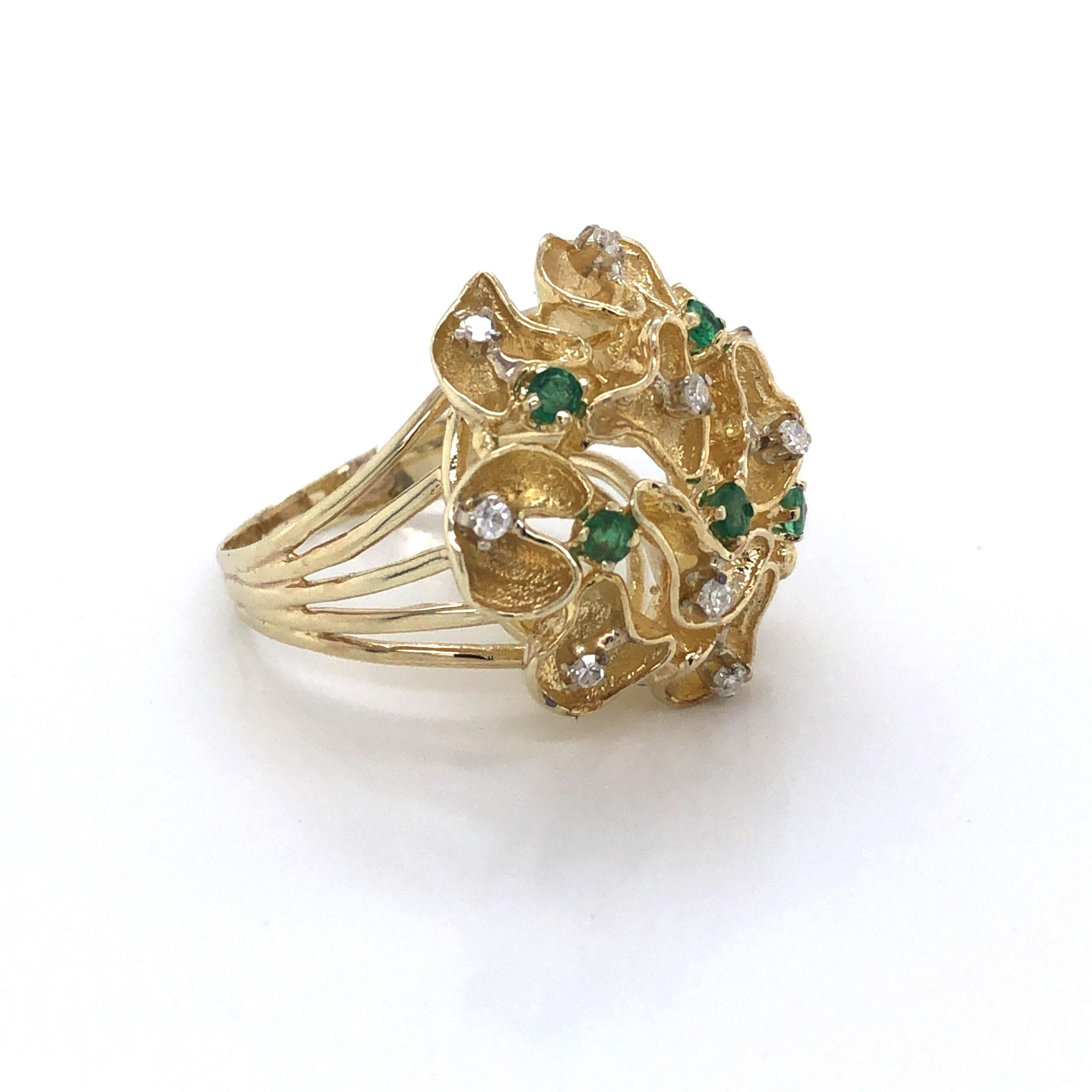 Lacey floral inspired buds of yellow gold are illuminated with emerald and diamonds accents to create this outstanding 1960's pop art style ring. Made of fourteen karat 14k yellow gold with eleven .01 carat diamonds, .11 carat total weight and five