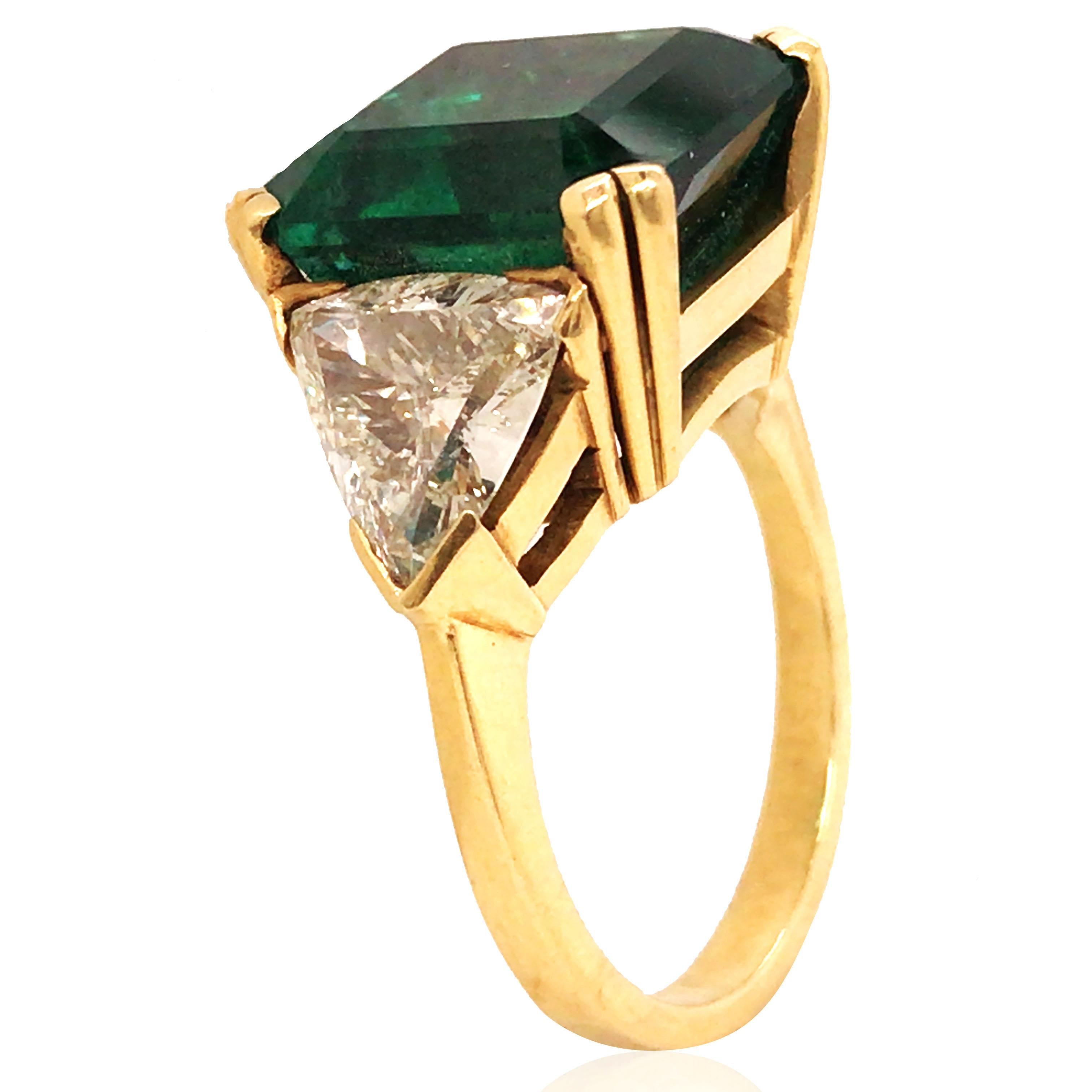 This is an elegant ring featuring a 7.5ct Zambian emerald as the central stone, showcasing its unique green brilliance. On each side, approximately 3ct of diamonds enhance the luxurious feel of the ring. Crafted in 18K gold, the ring is size 6.5 and
