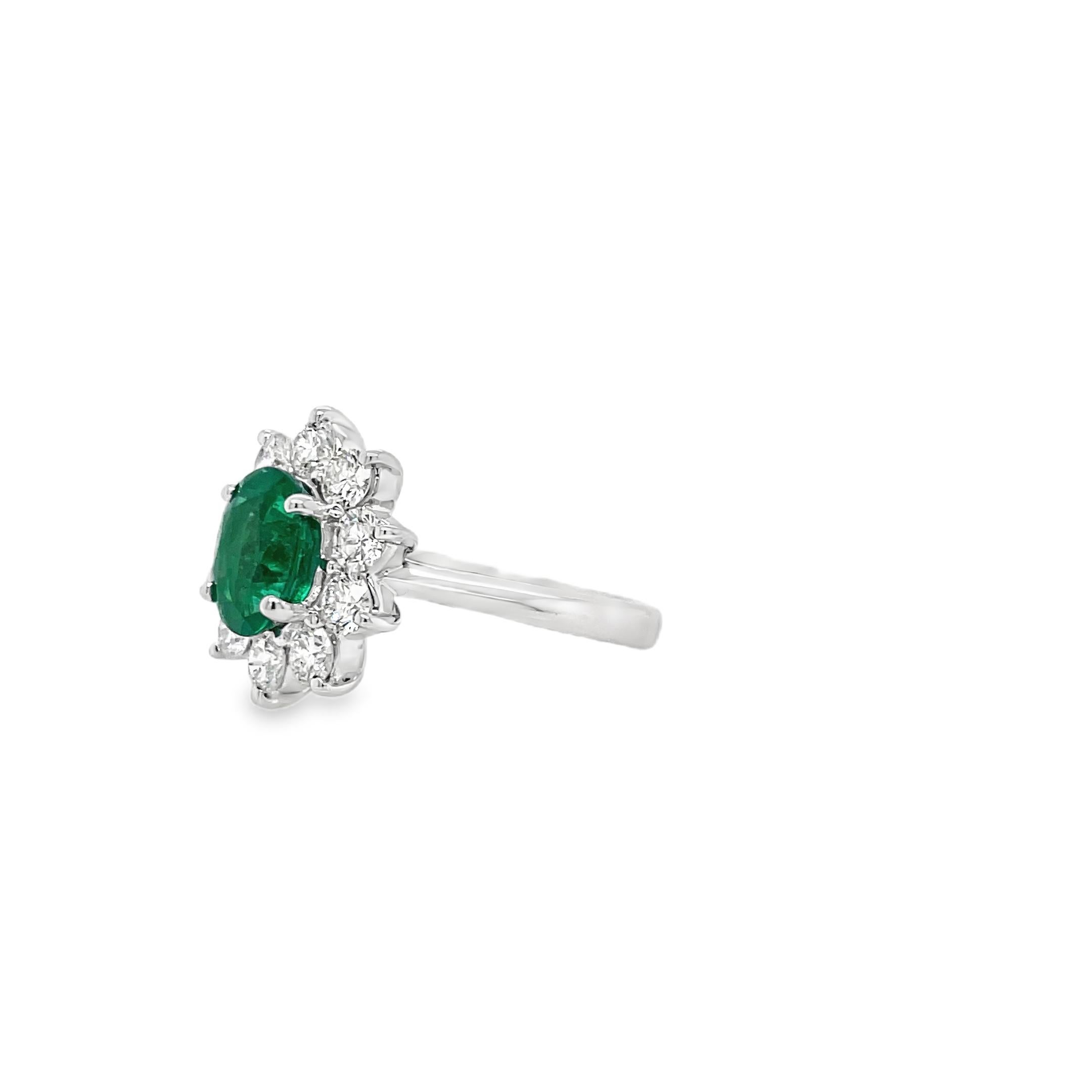 Ring contains one center oval shape emerald weighing 1.44cts. Center stone is surrounded by round brilliant diamonds, 0.95tcw. Emearld and diamonds are mounted in handmade prong settings. Diamonds are F in color and VS2 in clarity. Emerald