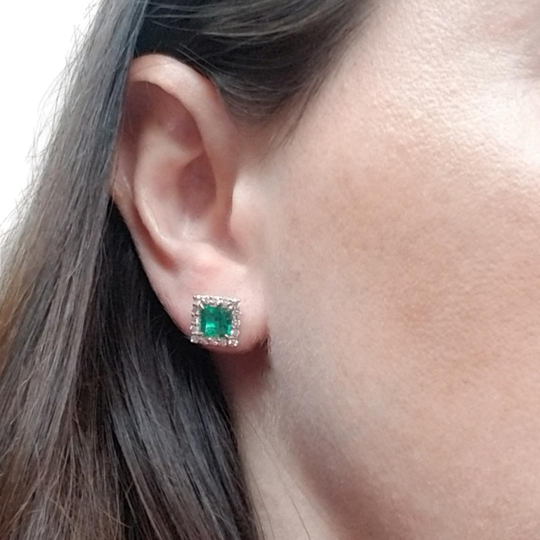 14 Karat Yellow Gold Stud Earrings Featuring 2 Square Emerald Cut Emeralds Totaling 1.73 Carat. They Are Accented By 32 Round Diamonds Totaling 0.64 Carat of VS Clarity & G Color. Pierced Post with Friction Back.