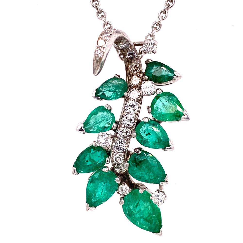 Beautiful diamond emerald pendant necklace. The necklace features 8 round brilliant cut diamonds dangling from the necklace. The leaf motif pendant is set with 9 bright green emeralds weighing 4.50 carats. There are 29 round brilliant cut diamonds