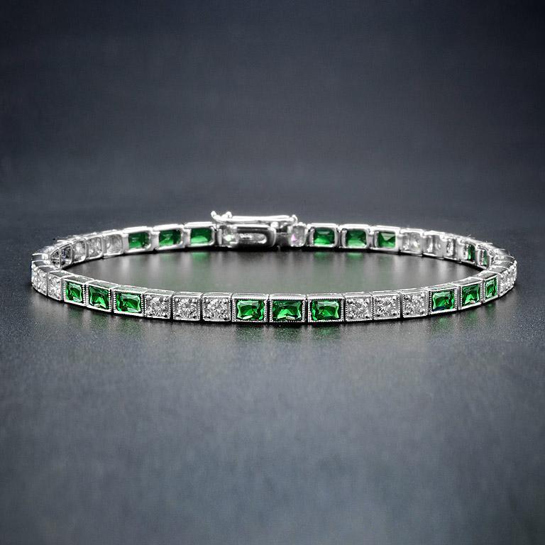 A gorgeous gemstone line bracelet from the Art Deco era! Crafted in 18K white gold, this fabulous piece features an alternating pattern comprised of sections of emerald and diamonds. The bracelet fastens at a push clasp seamlessly hidden within the