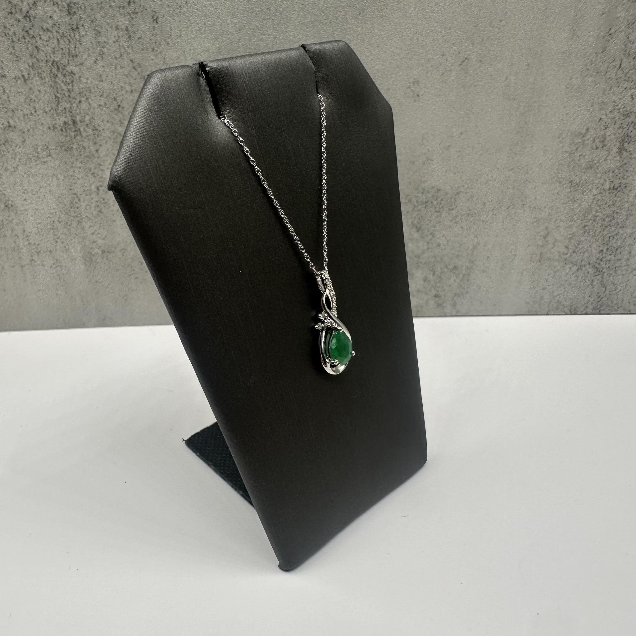 Questa elegante collana di smeraldi e diamanti in oro bianco 10 carati è caratterizzata da uno smeraldo a forma di pera di circa 6,8x4,9 mm, arricchito da 0,05 carati di diamanti naturali GH SI2-I1 a taglio singolo. Con una lunghezza di 18 pollici e