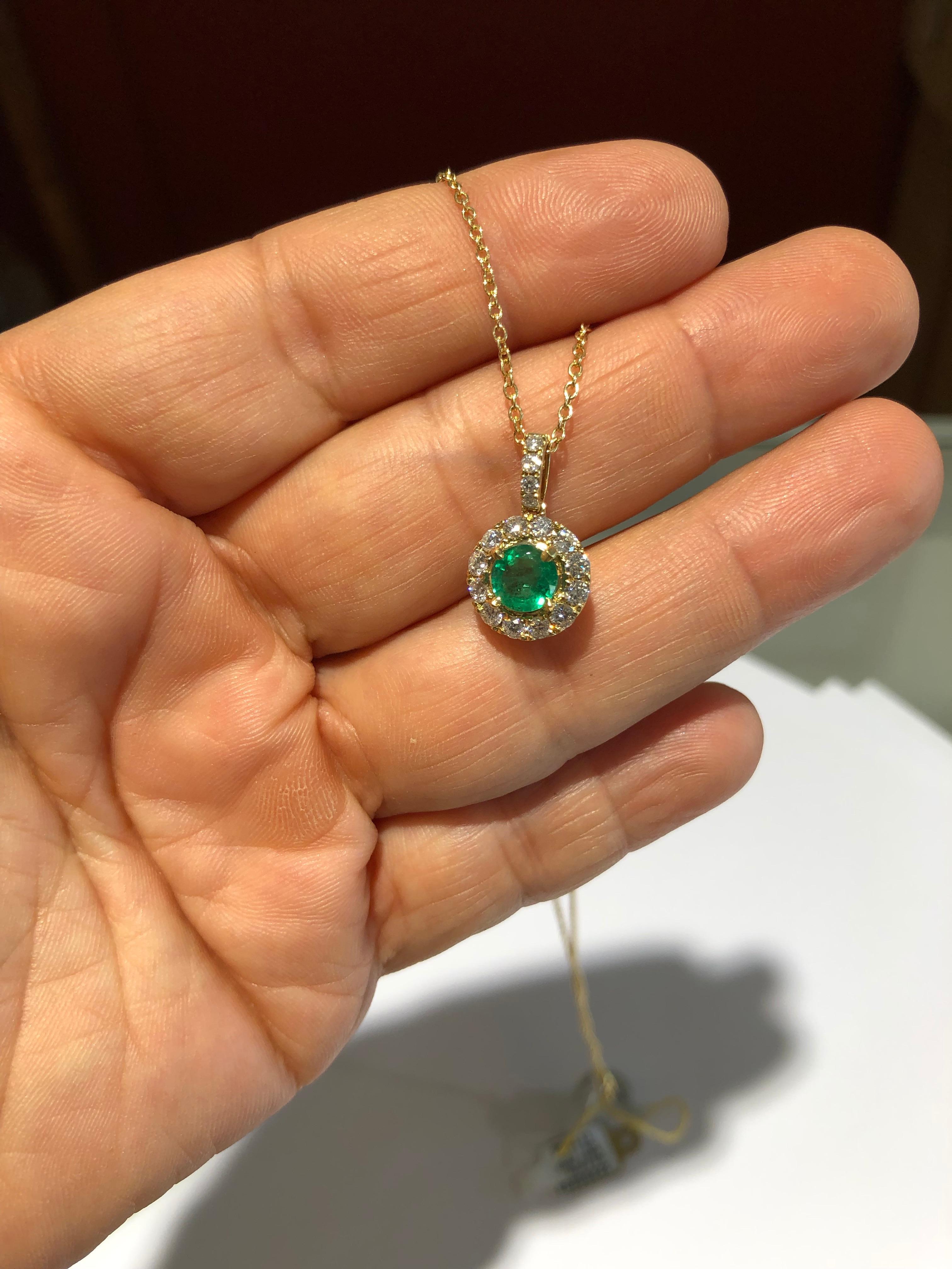 Beautiful and classic pendant set with a round cut Colombian emerald approx. 0.74ct surrounded by round brilliant cut diamond  approx. 0.63ct G-H SI1. Mounted on 14k yellow gold Contemporary work, 17 inches chain. Total necklace weigh 4.2g
